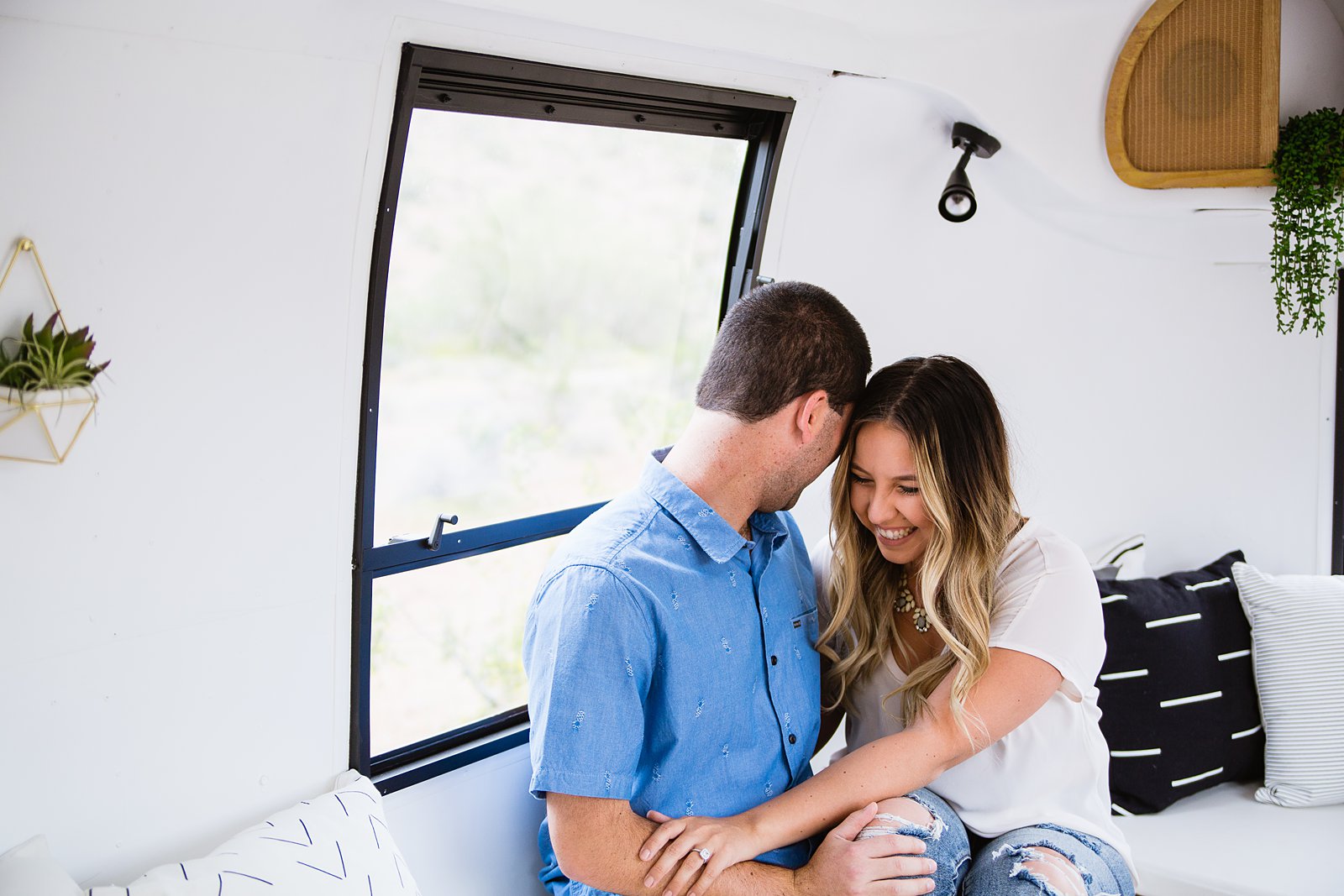 Couple laugh together during their Air Stream engagement session by Phoenix engagement photographer PMA Photography.