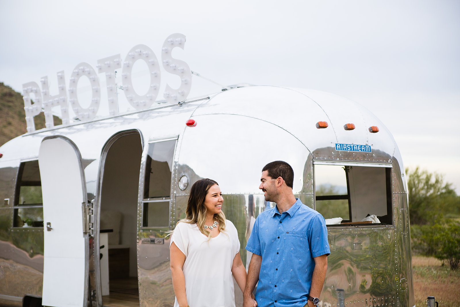 Couple look at each other during their Air Stream engagement session by Phoenix wedding photographer PMA Photography.