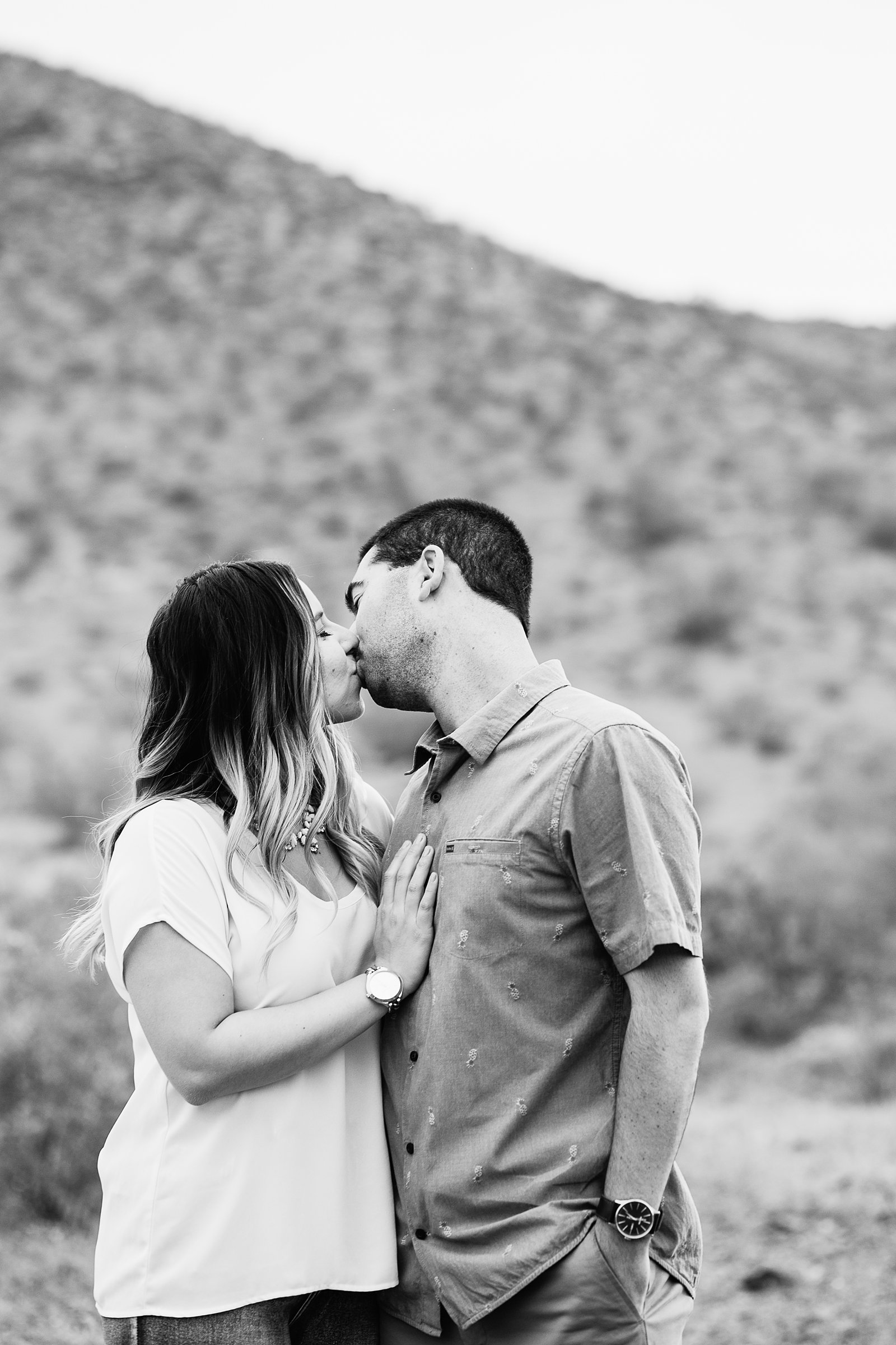 Couple share a kiss during their Thunderbird Mountain engagement session by Phoenix wedding photographer PMA Photography.