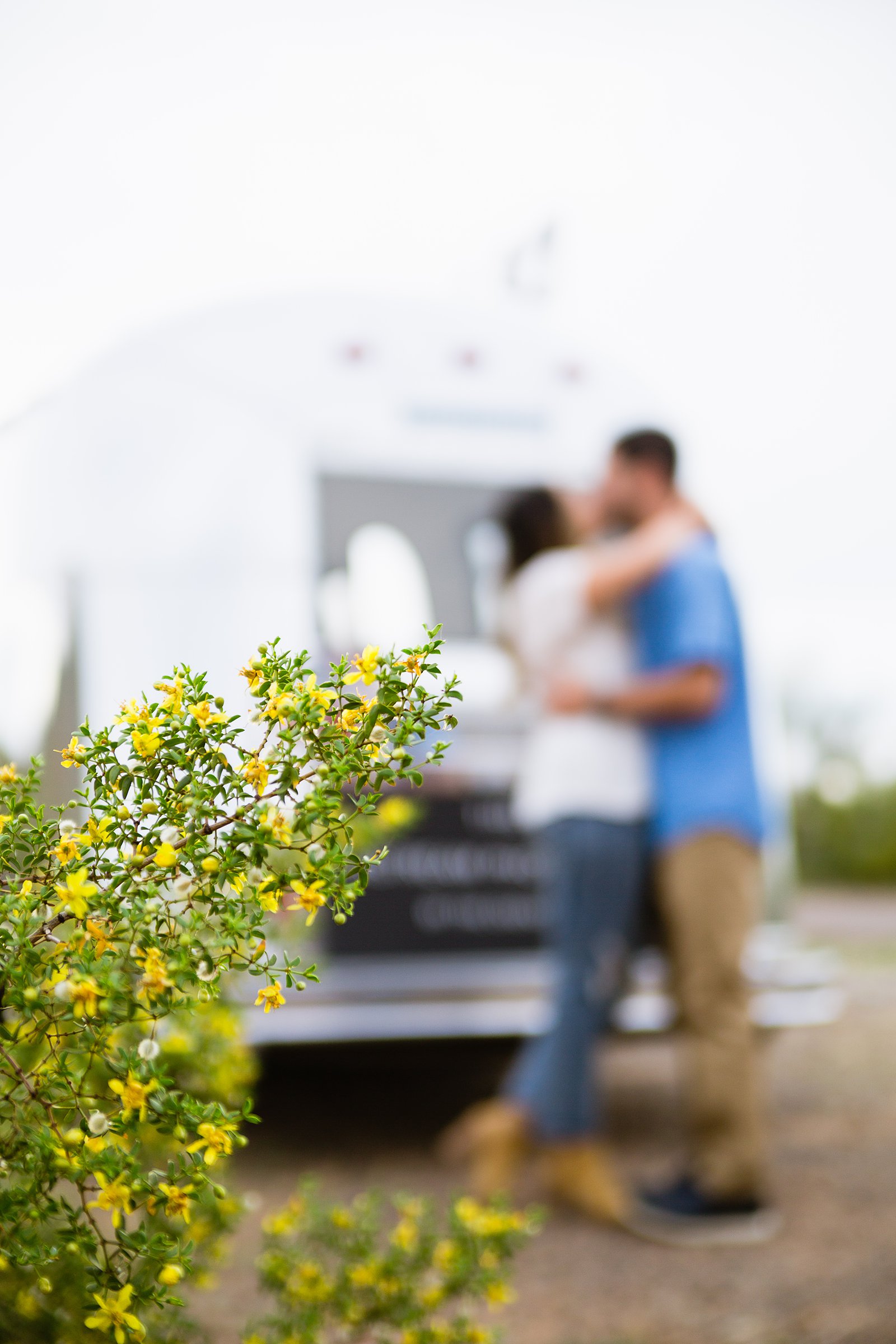 Couple share a kiss during their Air Stream engagement session by Phoenix wedding photographer PMA Photography.