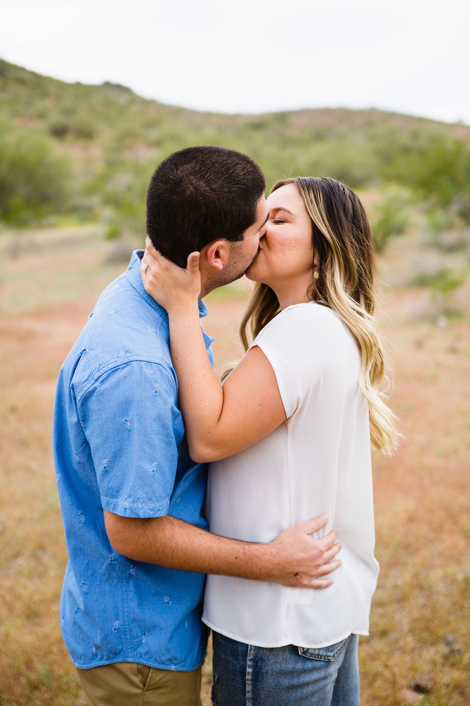Couple share a kiss during their Thunderbird Mountain engagement session by Phoenix wedding photographer PMA Photography.