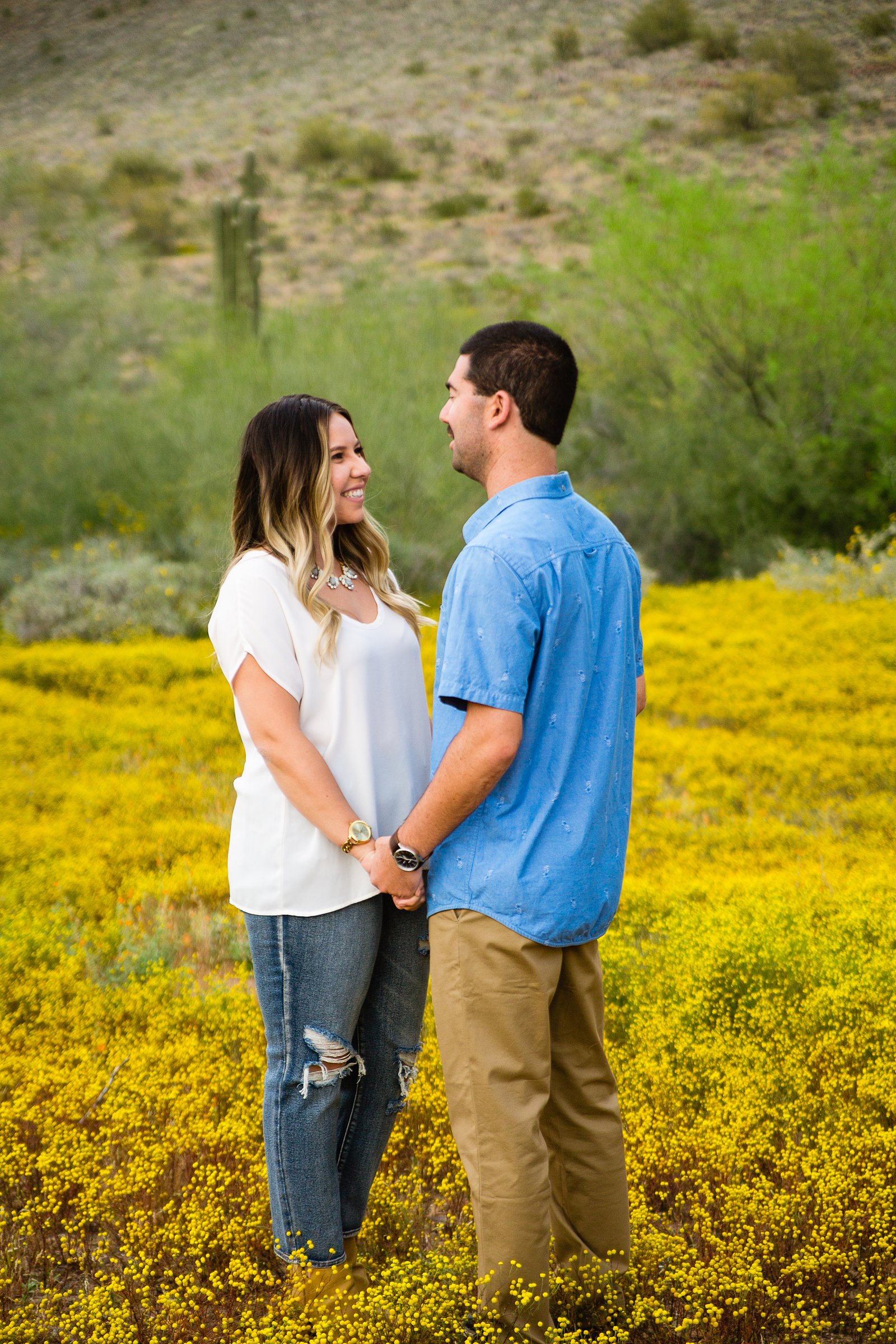Couple look at each other during their Spring Thunderbird Mountain engagement session by Phoenix wedding photographer PMA Photography.