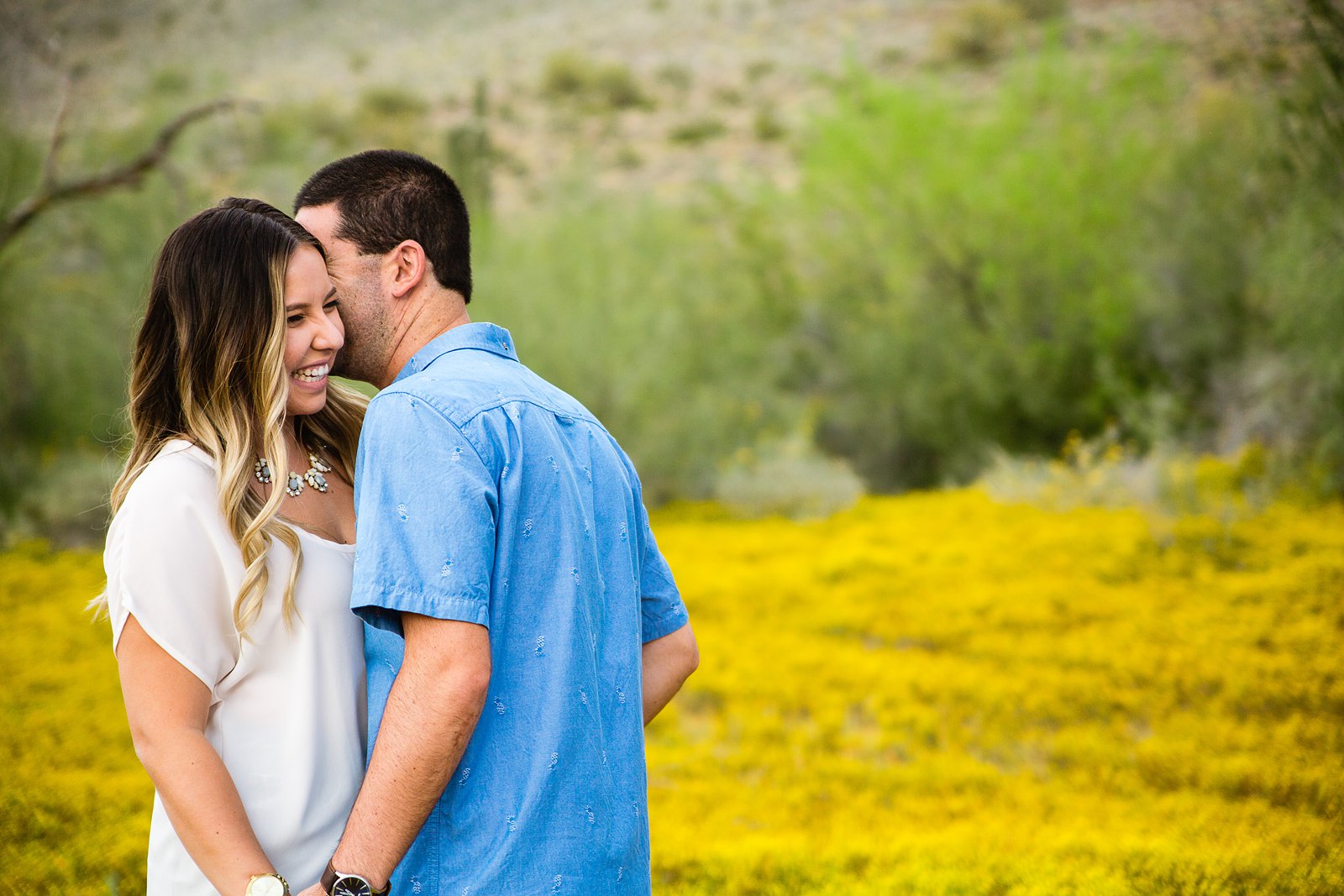 Couple laugh together during their Spring Thunderbird Mountain engagement session by Phoenix engagement photographer PMA Photography.