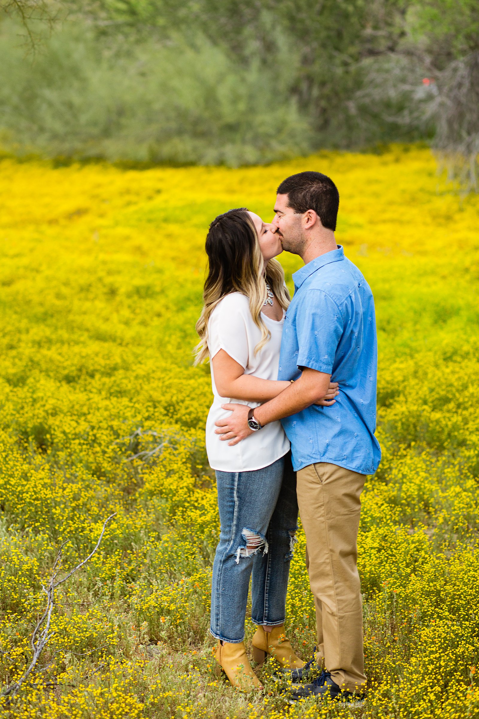 Couple share a kiss during their Spring Thunderbird Mountain engagement session by Phoenix wedding photographer PMA Photography.
