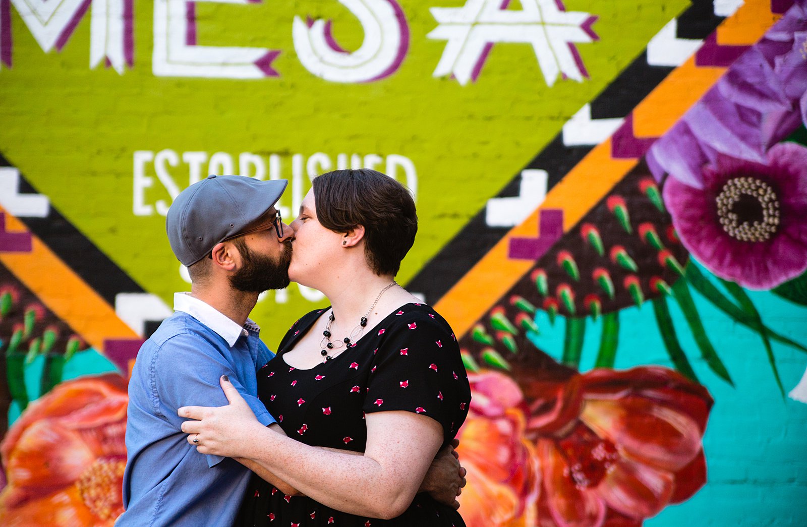 Couple share a kiss during their Downtown Mesa engagement session by Phoenix wedding photographer PMA Photography.