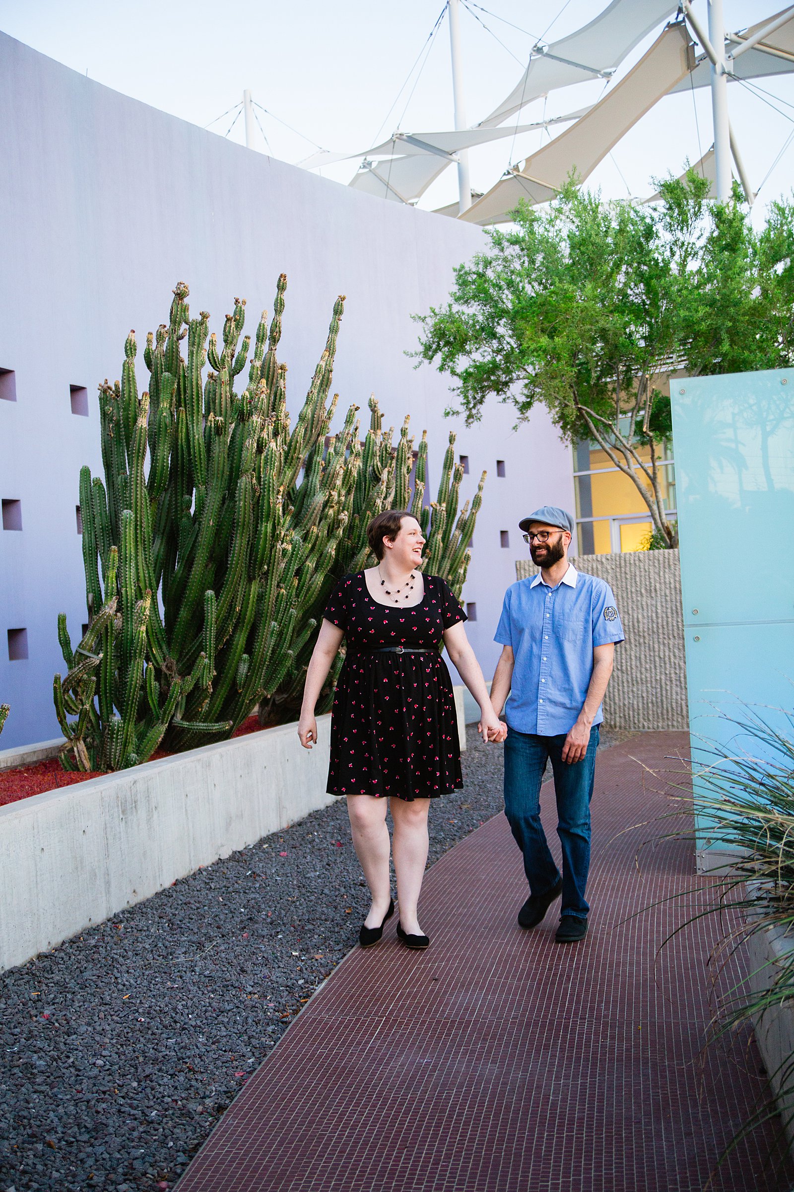 Couple walking together during their Mesa Arts Center engagement session by Phoenix engagement photographer PMA Photography.