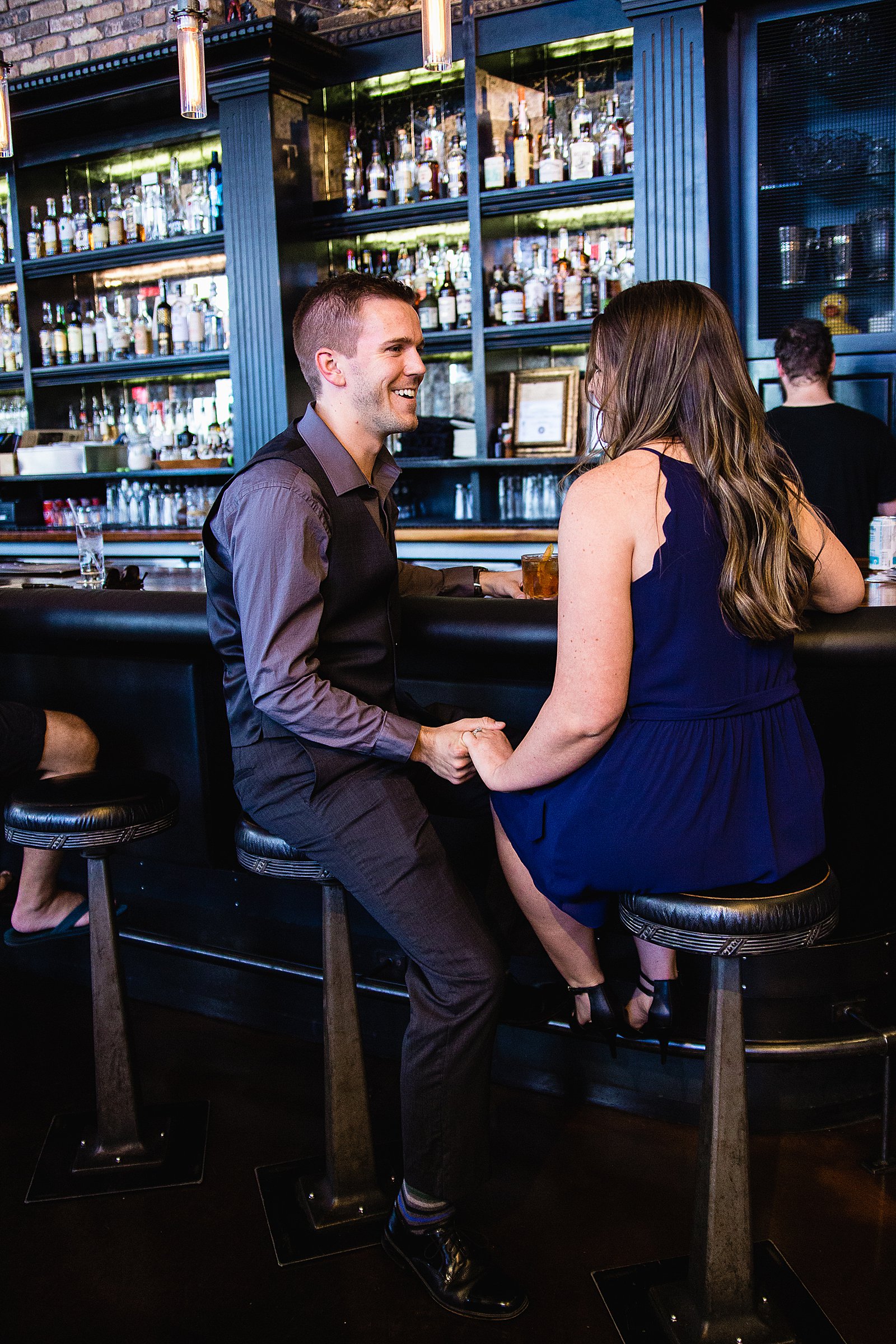 Couple pose for their Downtown Phoenix bar engagement session by Phoenix wedding photographer PMA Photography.