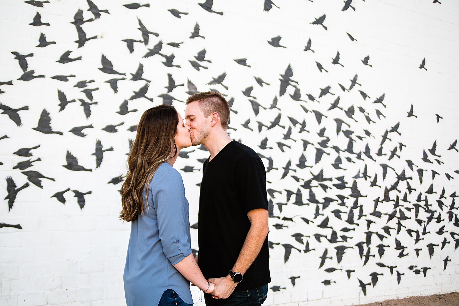 Couple share a kiss during their Roosevelt Row engagement session by Phoenix wedding photographer PMA Photography.