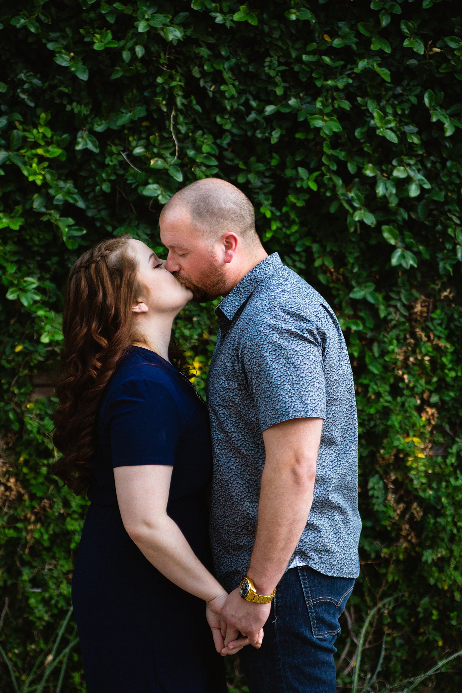 Couple share a kiss during their Phoenix engagement session by Arizona wedding photographer PMA Photography.