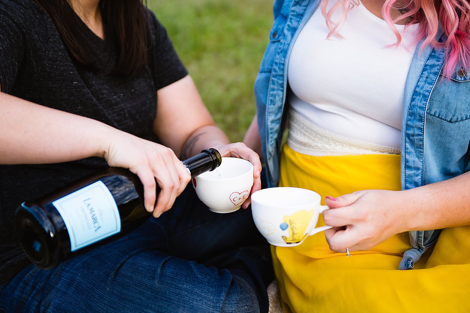Pouring champagne toasts into Disney's Up tea cups during a picnic engagement session by PMA Photography.