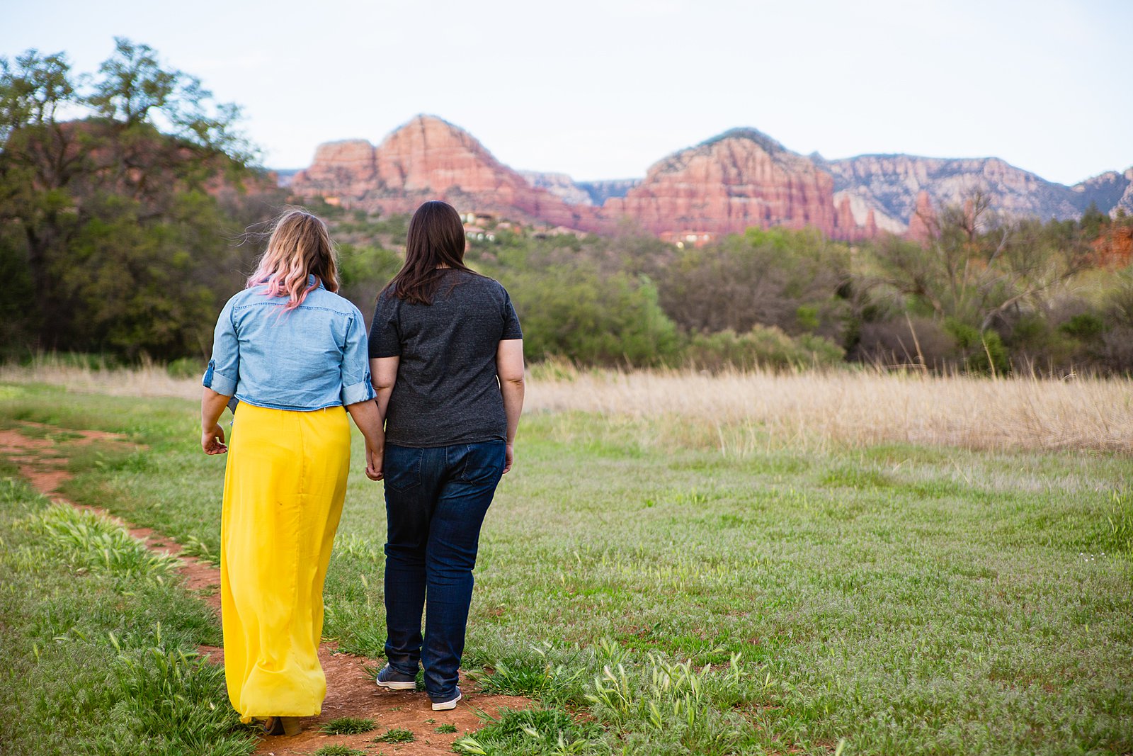 LGBT couple walking together during their Sedona engagement session by Arizona engagement photographer PMA Photography.