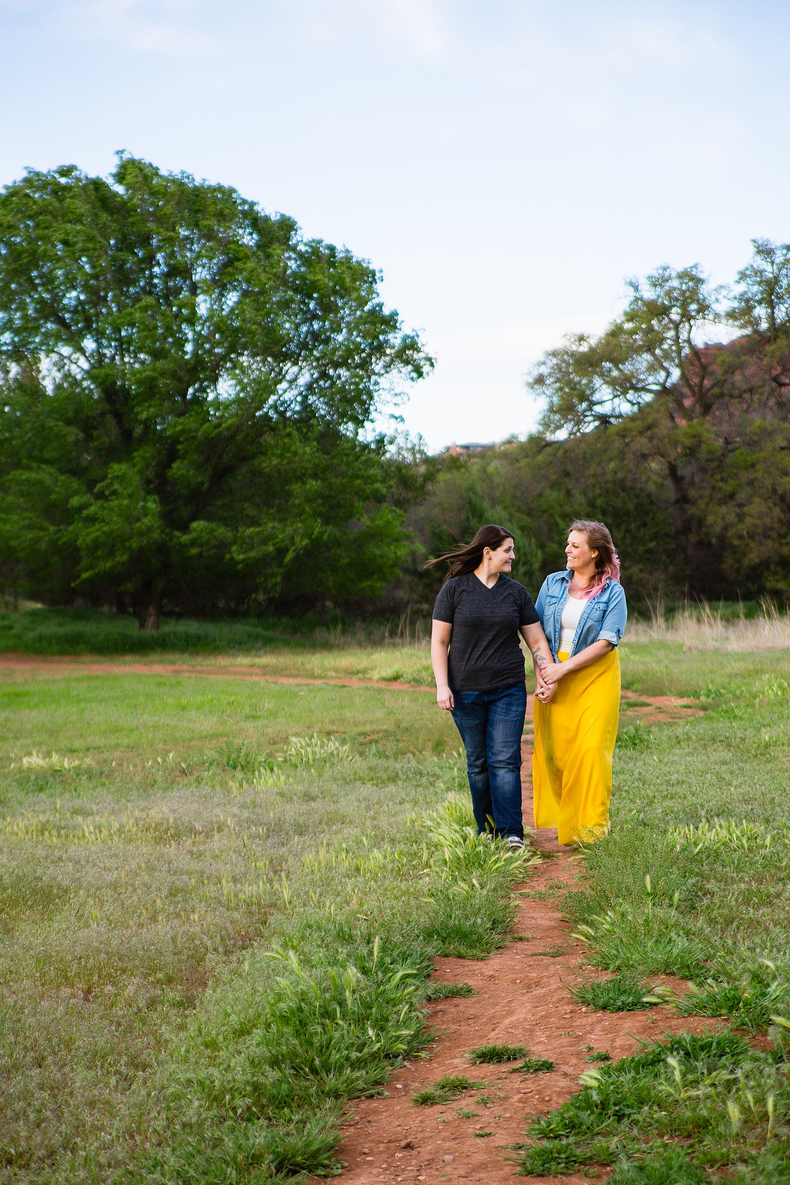 LGBT couple walking together during their Crescent Moon Ranch Picnic engagement session by Sedona engagement photographer PMA Photography.