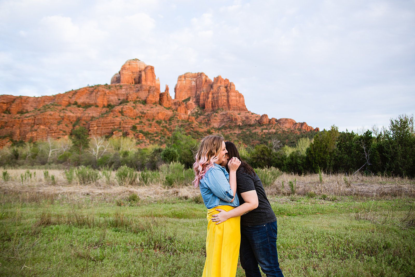 Same Sex couple laugh together during their Sedona engagement session by Arizona engagement photographer PMA Photography.
