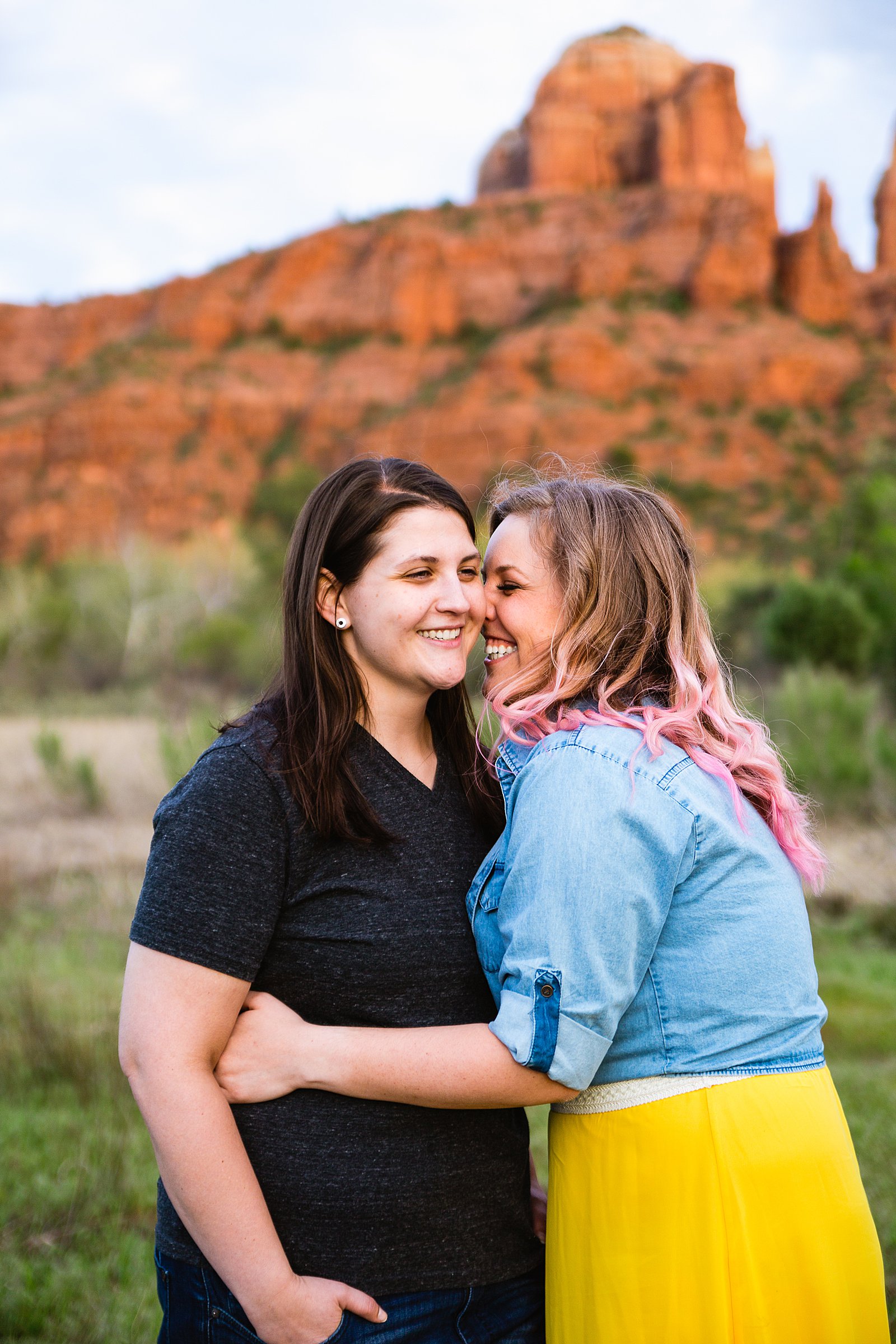 LGBTQ couple laugh together during their Sedona engagement session by Arizona engagement photographer PMA Photography.