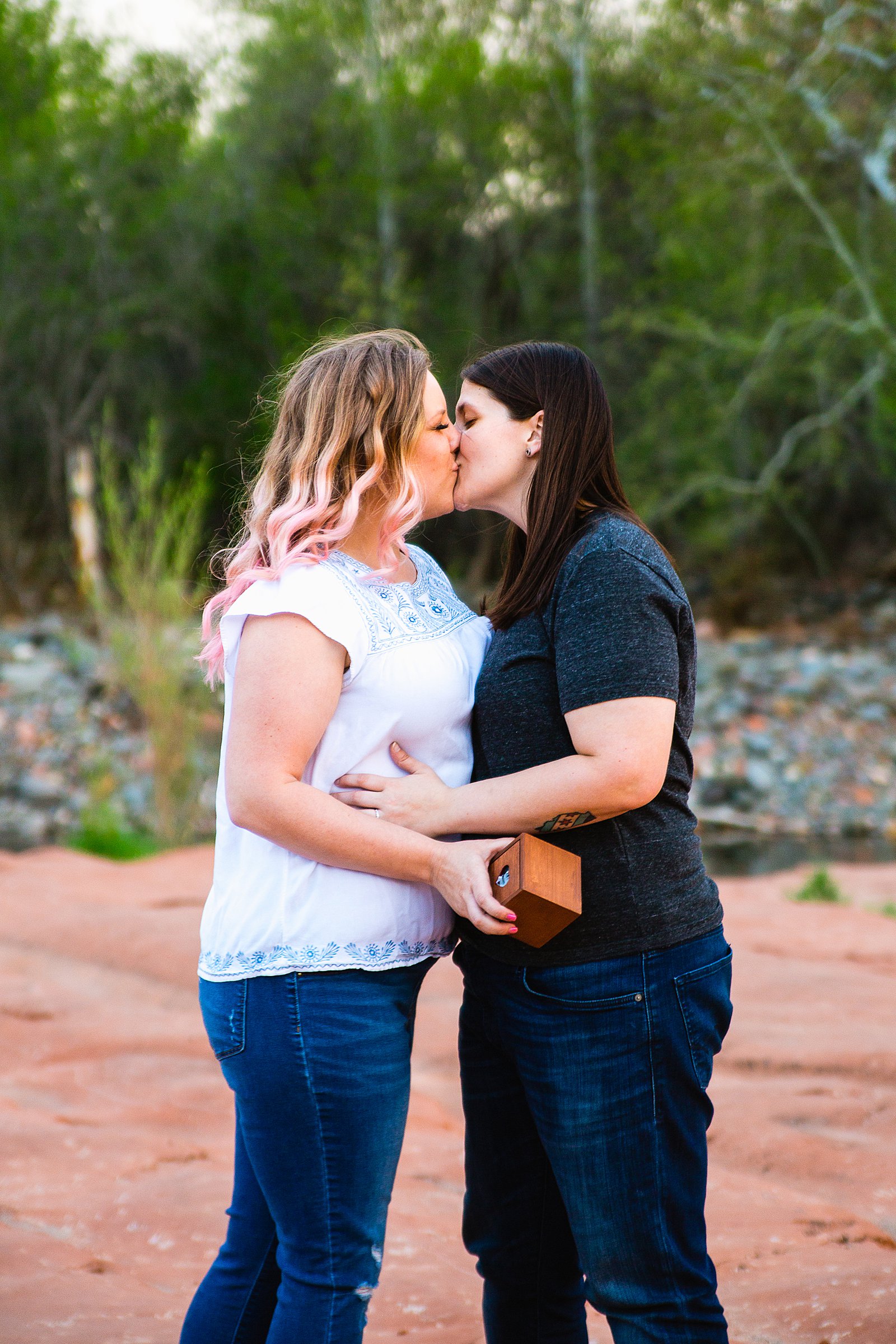 LGBTQ couple share a kiss during their Crescent Moon Ranch engagement session by Sedona wedding photographer PMA Photography.