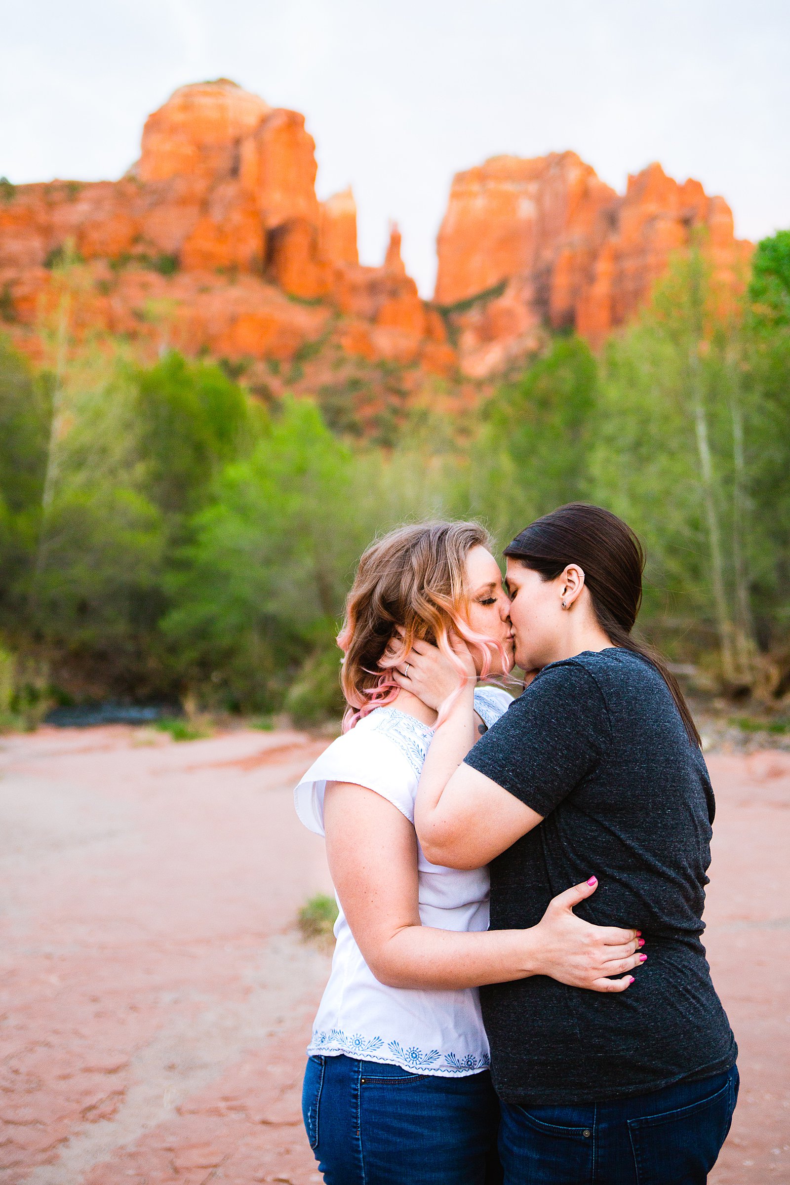 Same Sex couple share a kiss during their Crescent Moon Ranch engagement session by Sedona wedding photographer PMA Photography.