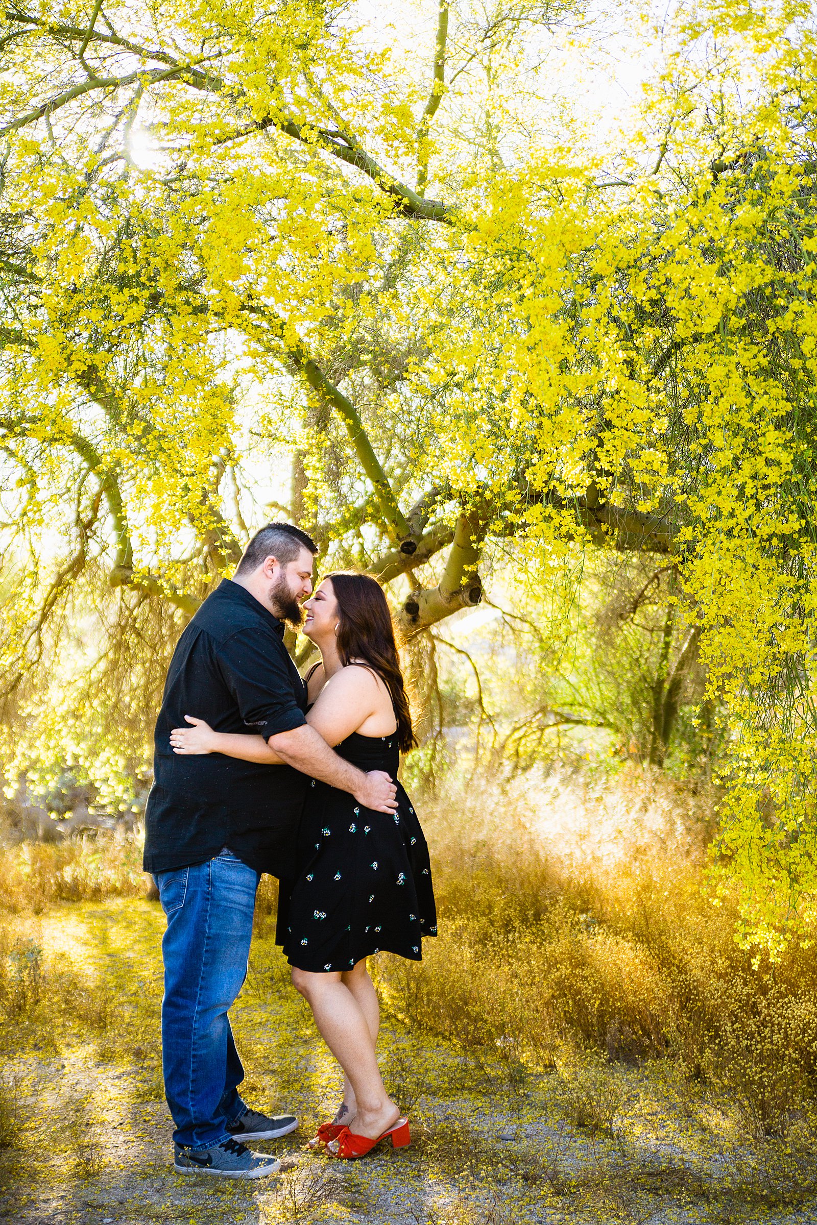 Couple share an intimate moment during their spring Thunderbird Mountain engagement session by Phoenix engagement photographer PMA Photography.
