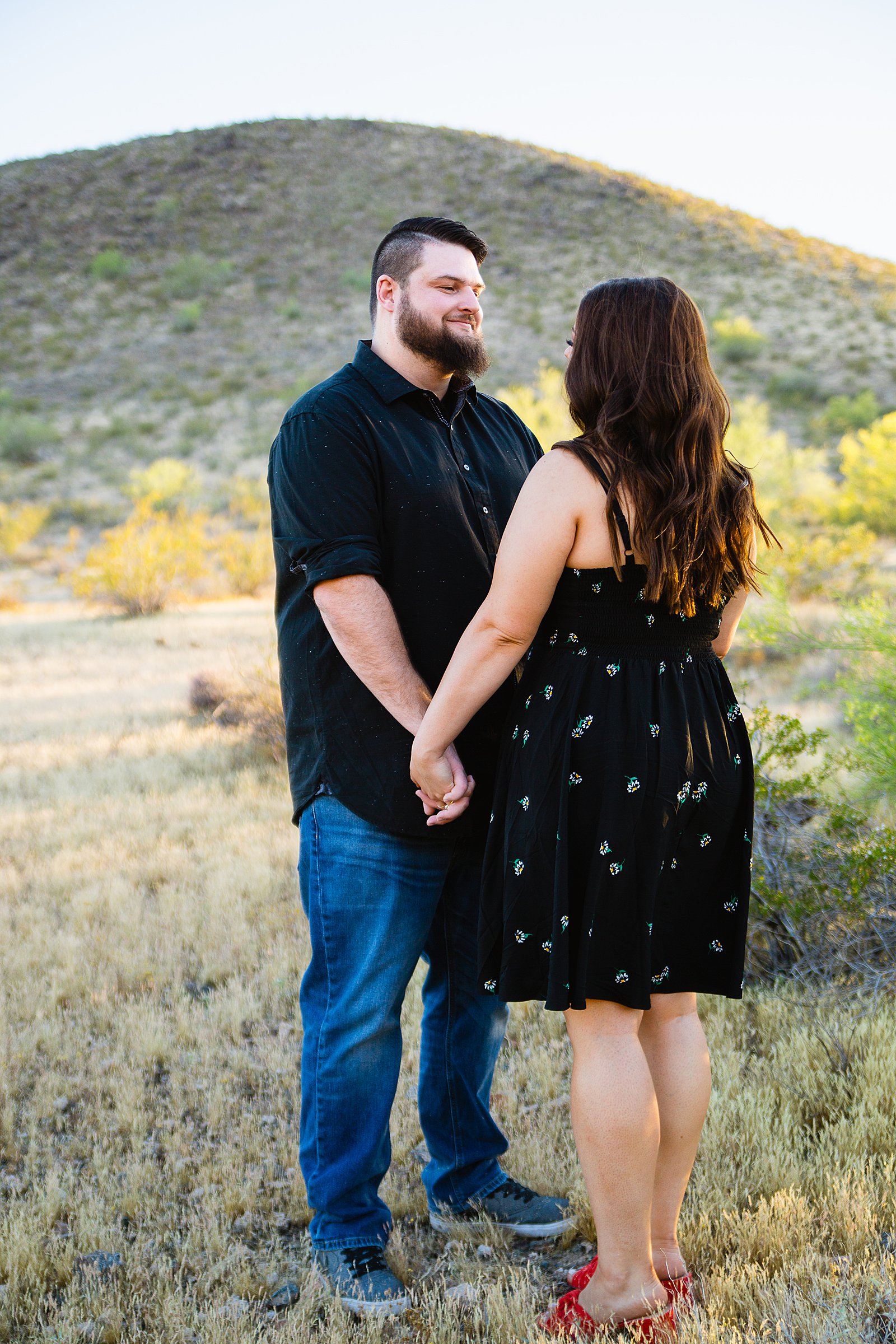Couple look at each other during their Thunderbird Mountain engagement session by Phoenix wedding photographer PMA Photography.