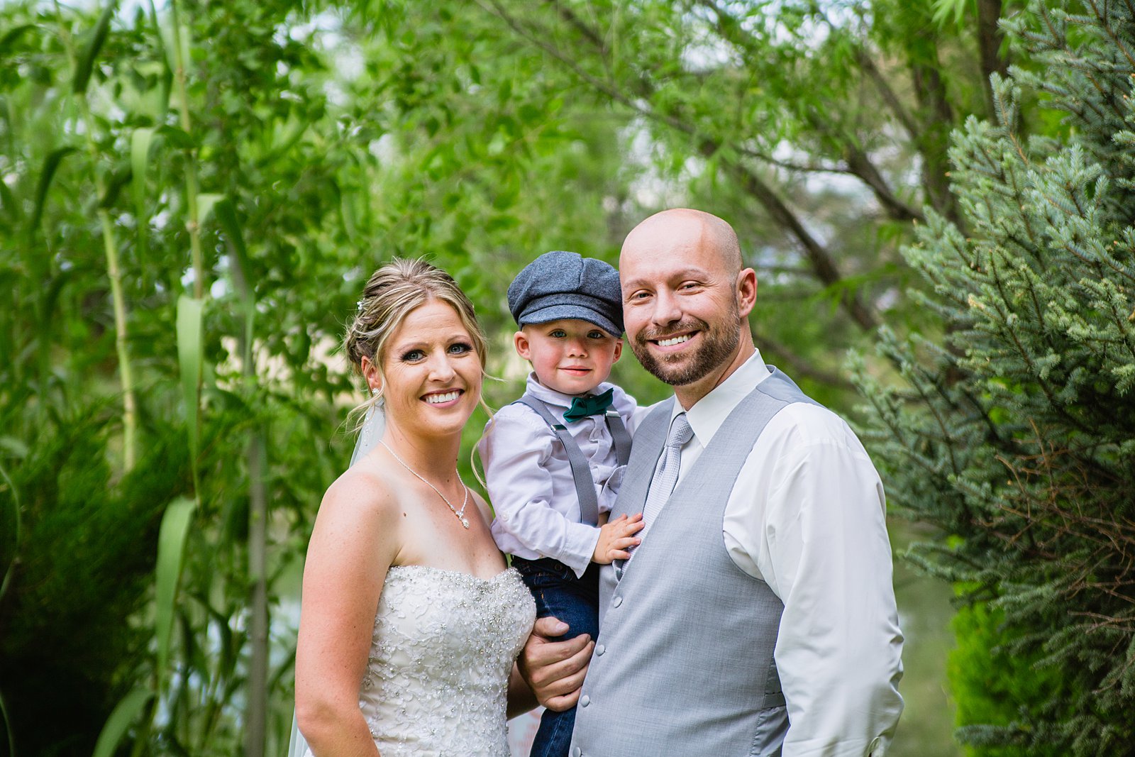 Bride and groom with their son on their wedding day by PMA Photography.