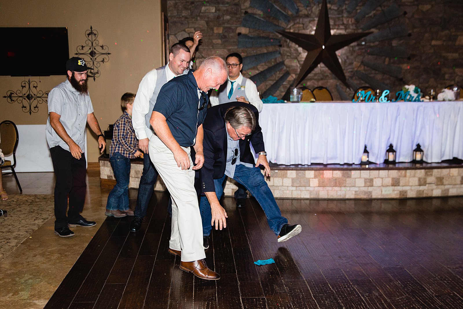 Garter toss at The Windmill House wedding reception by Chino Valley wedding photographer PMA Photography.