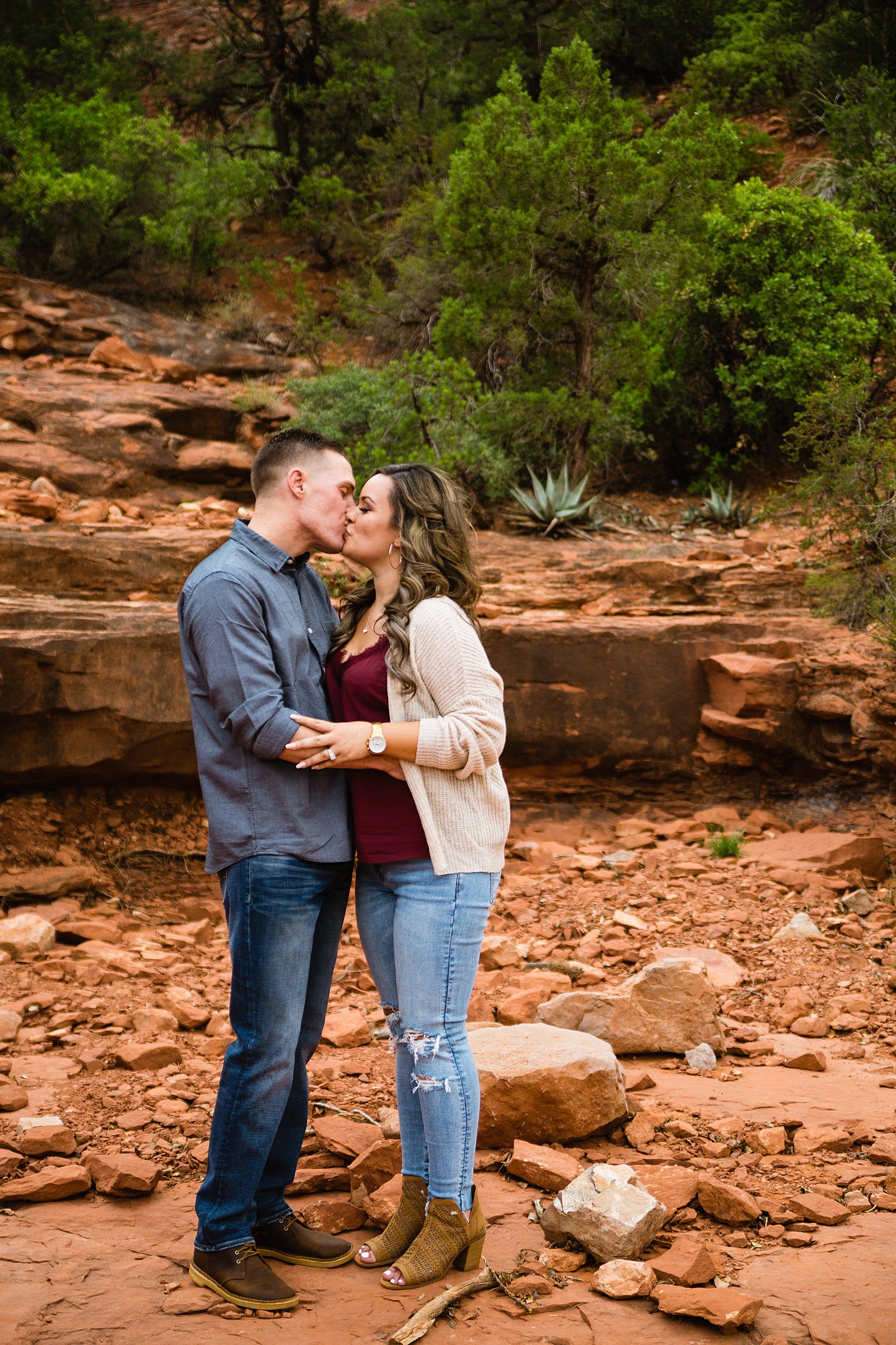 Couple share a kiss during their Cathedral Rock engagement session by Sedona wedding photographer PMA Photography.