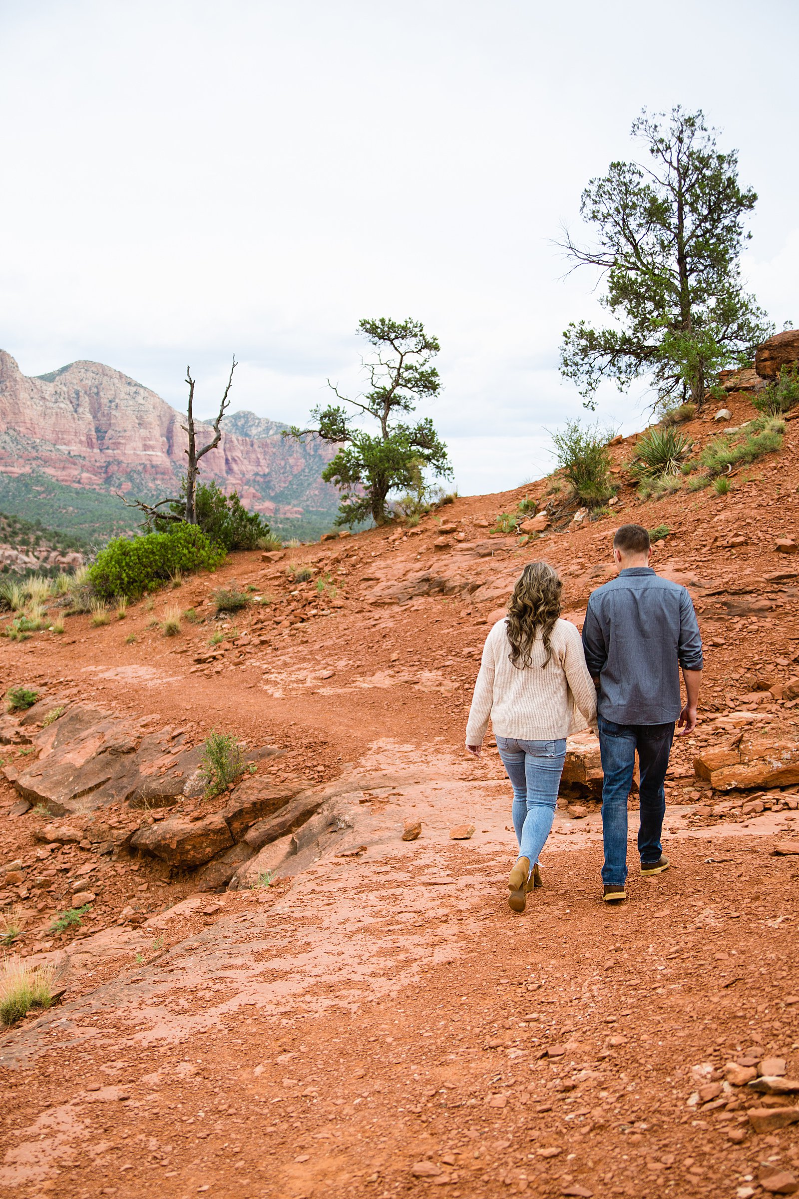 Couple walking together during their Cathedral Rock engagement session by Sedona engagement photographer PMA Photography.