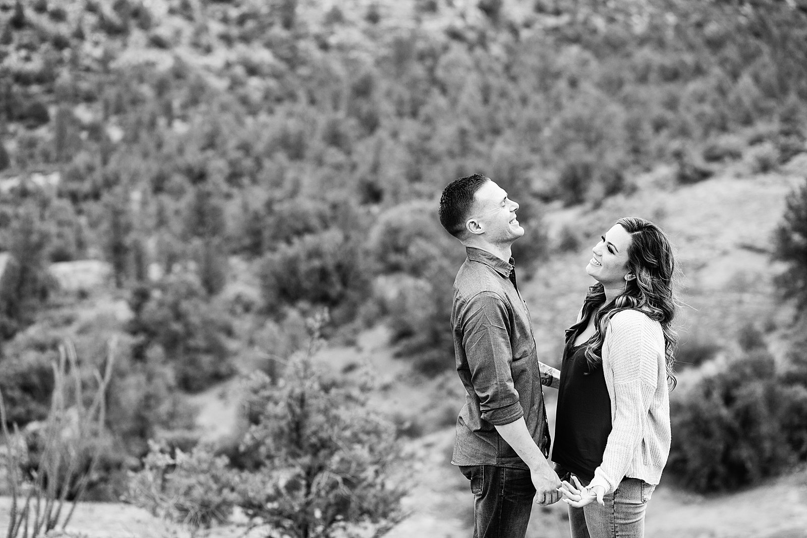 Couple laugh together during their Cathedral Rock engagement session by Sedona engagement photographer PMA Photography.