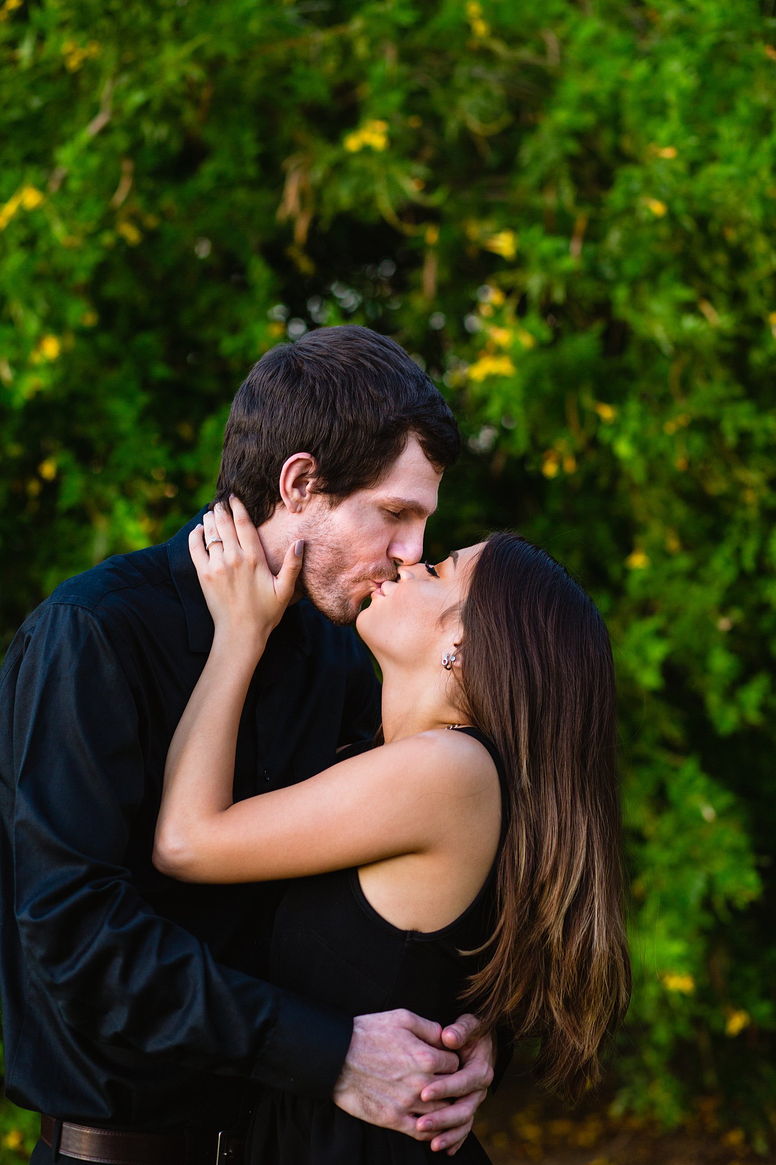 Couple share a kiss during their Downtown Gilbert engagement session by Gilbert wedding photographer PMA Photography.