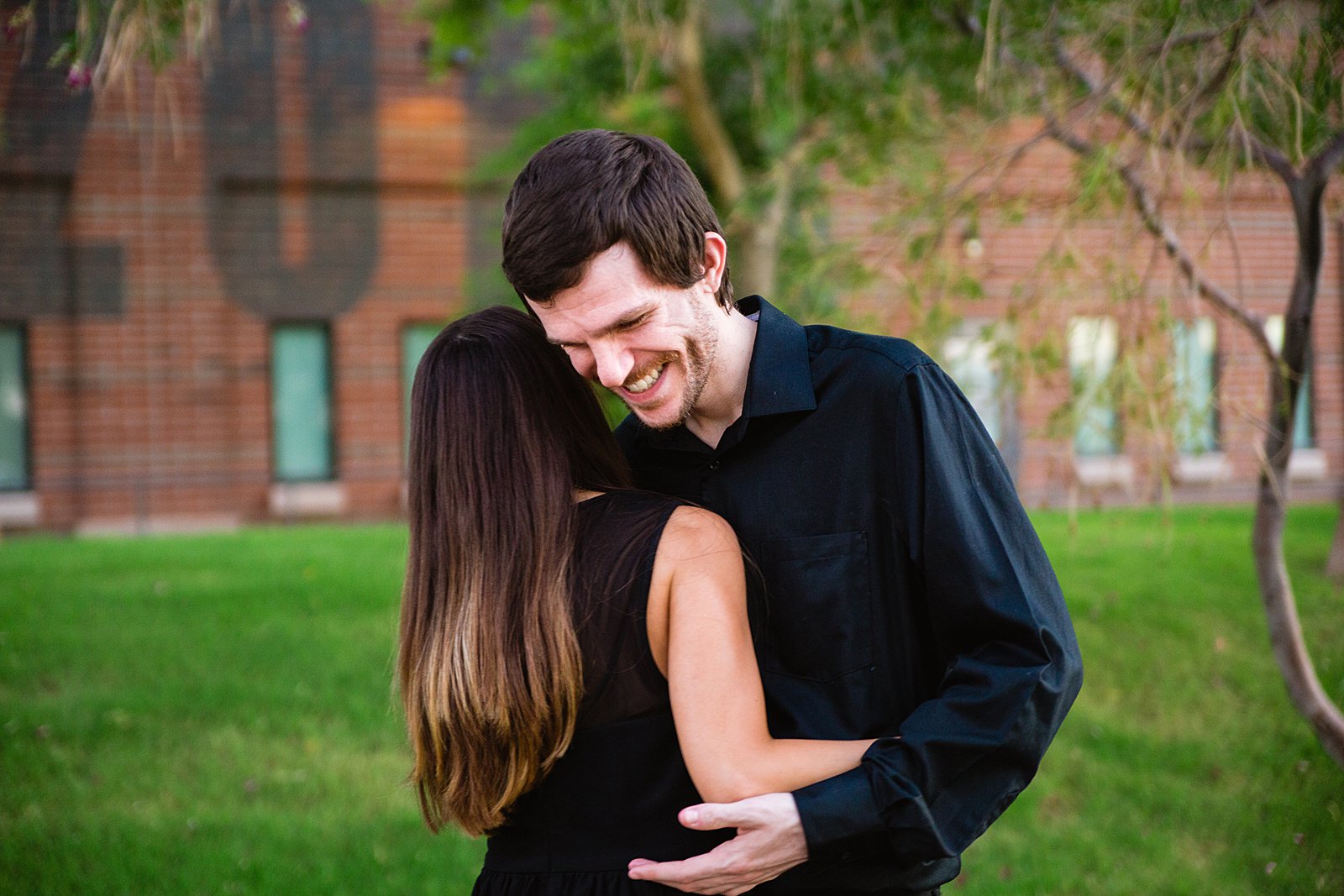 Couple laugh together during their Downtown Gilbert engagement session by Gilbert engagement photographer PMA Photography.