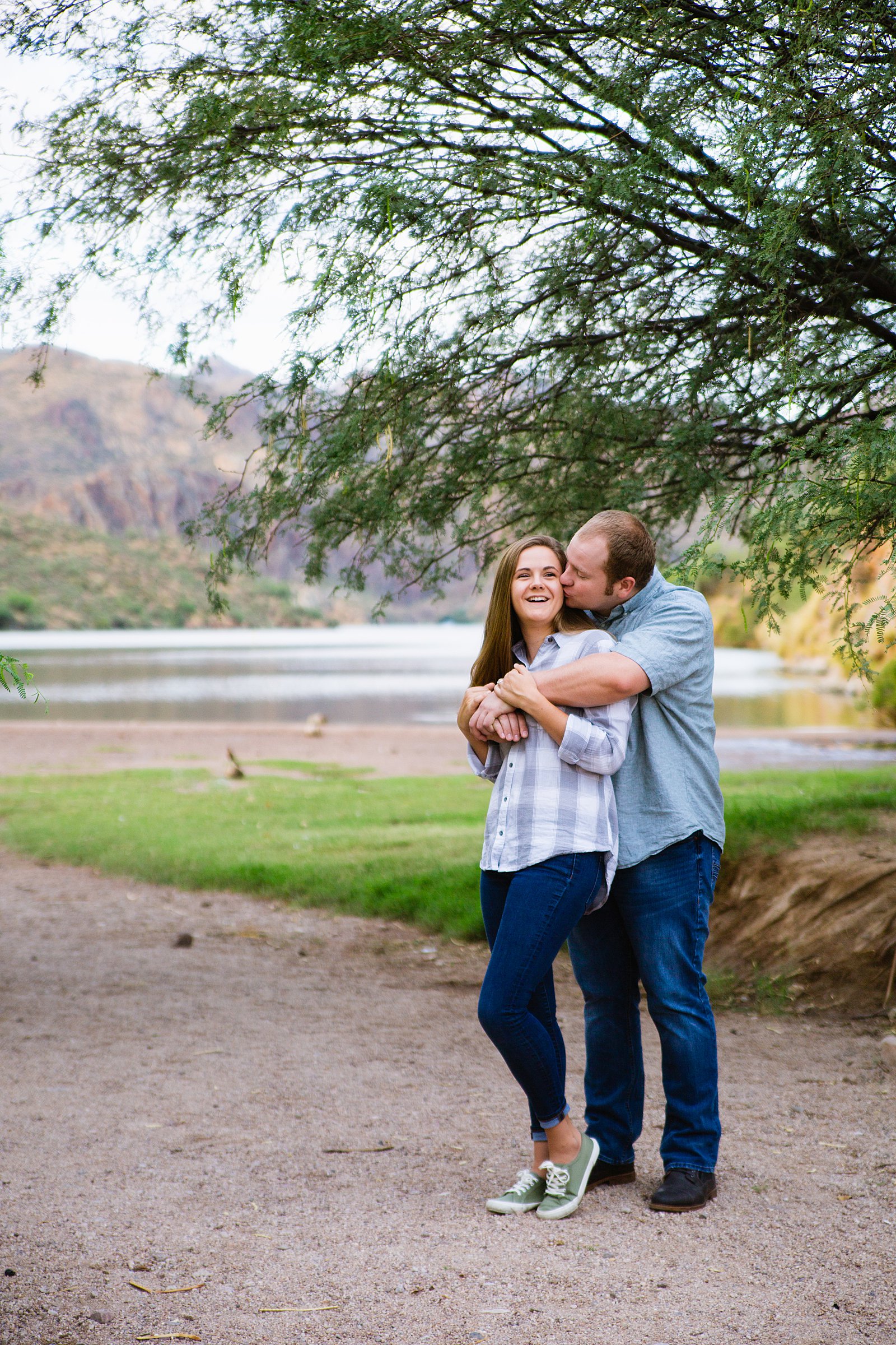 Couple laugh together during their Saguaro Lake engagement session by Phoenix engagement photographer PMA Photography.