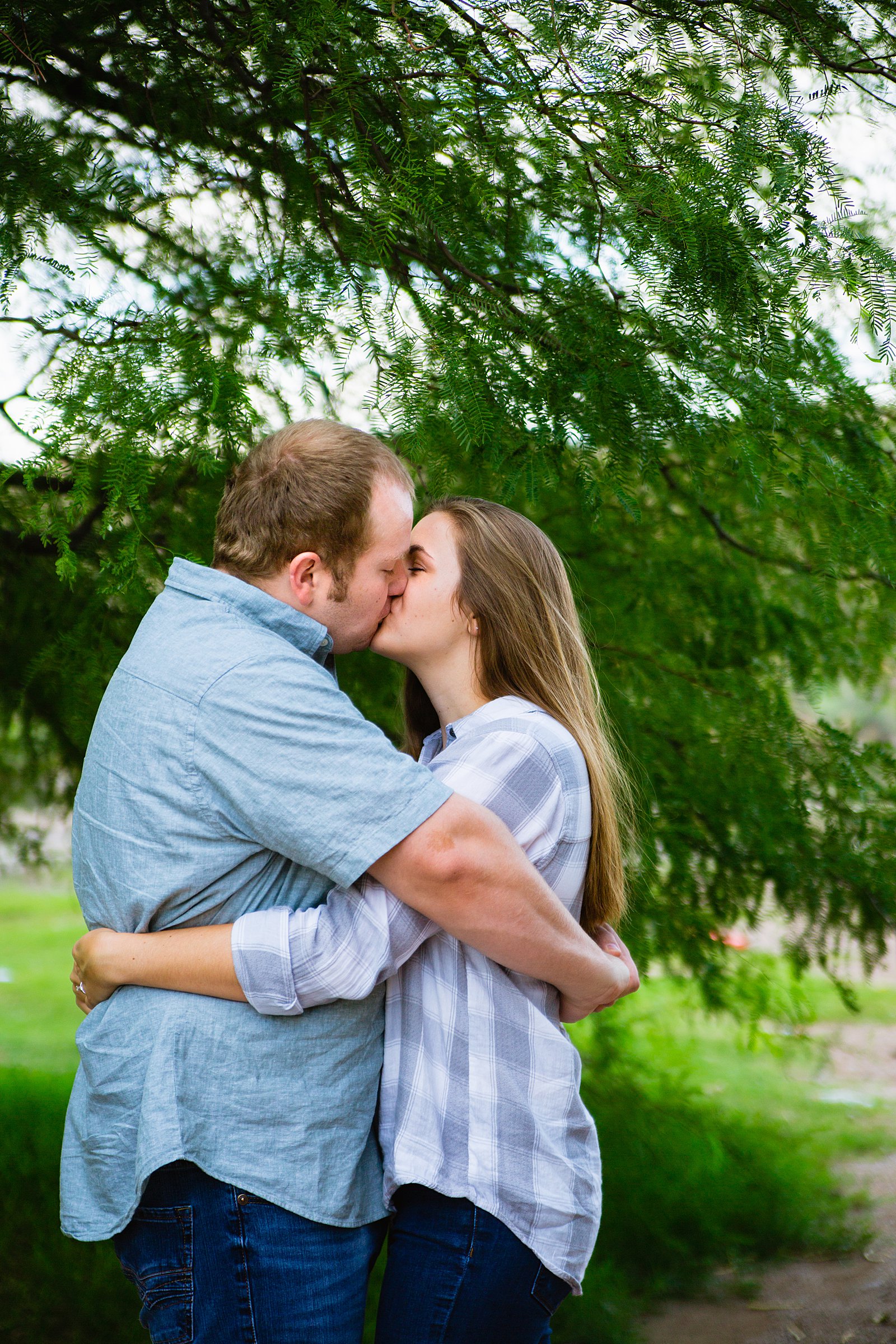 Couple share a kiss during their Saguaro Lake engagement session by Phoenix wedding photographer PMA Photography.