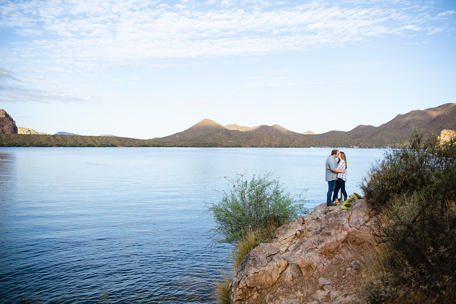 Couple share a kiss during their Saguaro Lake engagement session by Phoenix wedding photographer PMA Photography.