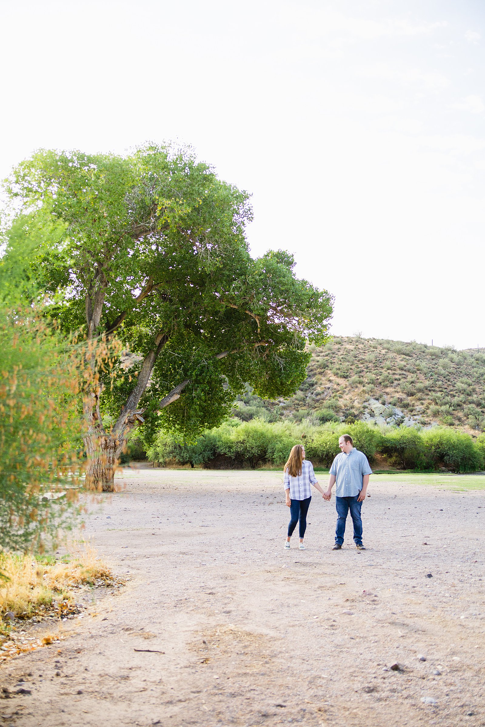 Couple look at each other during their Saguaro Lake engagement session by Phoenix wedding photographer PMA Photography.