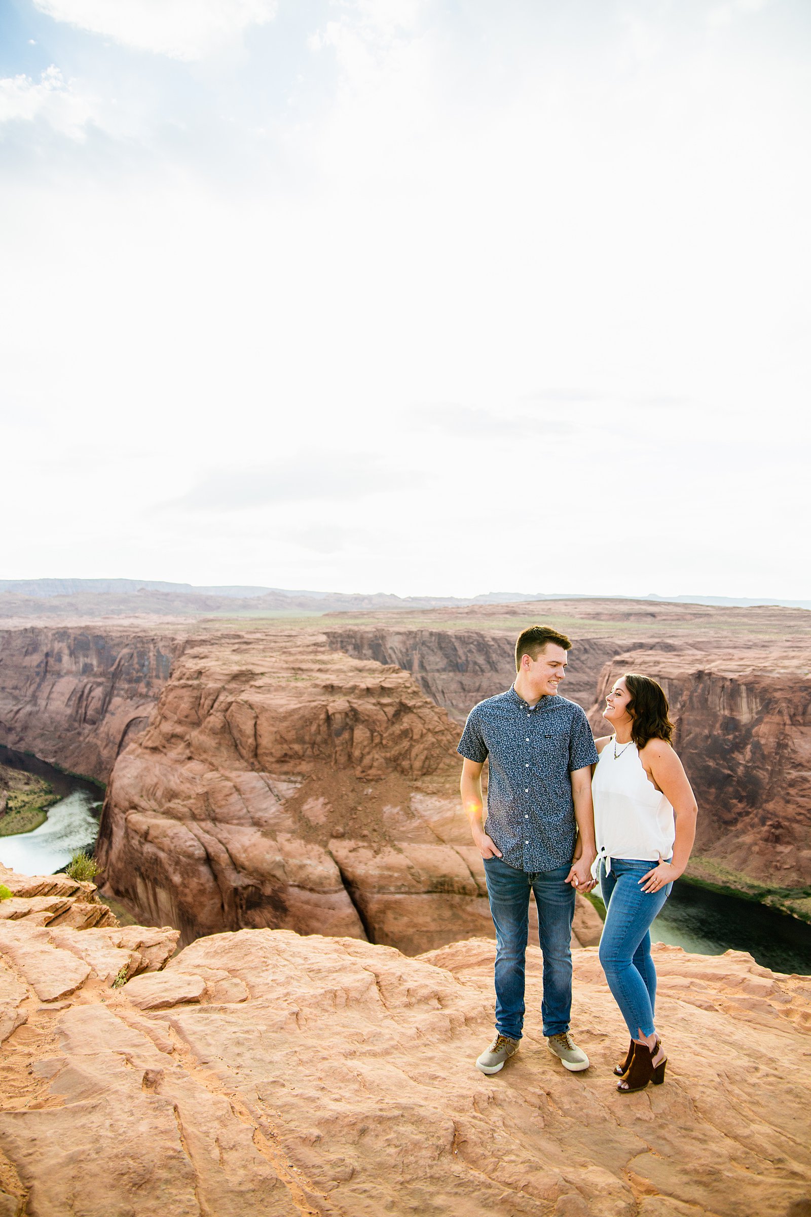 Couple look at each other during their Horshoe Bend engagement session by Page wedding photographer PMA Photography.