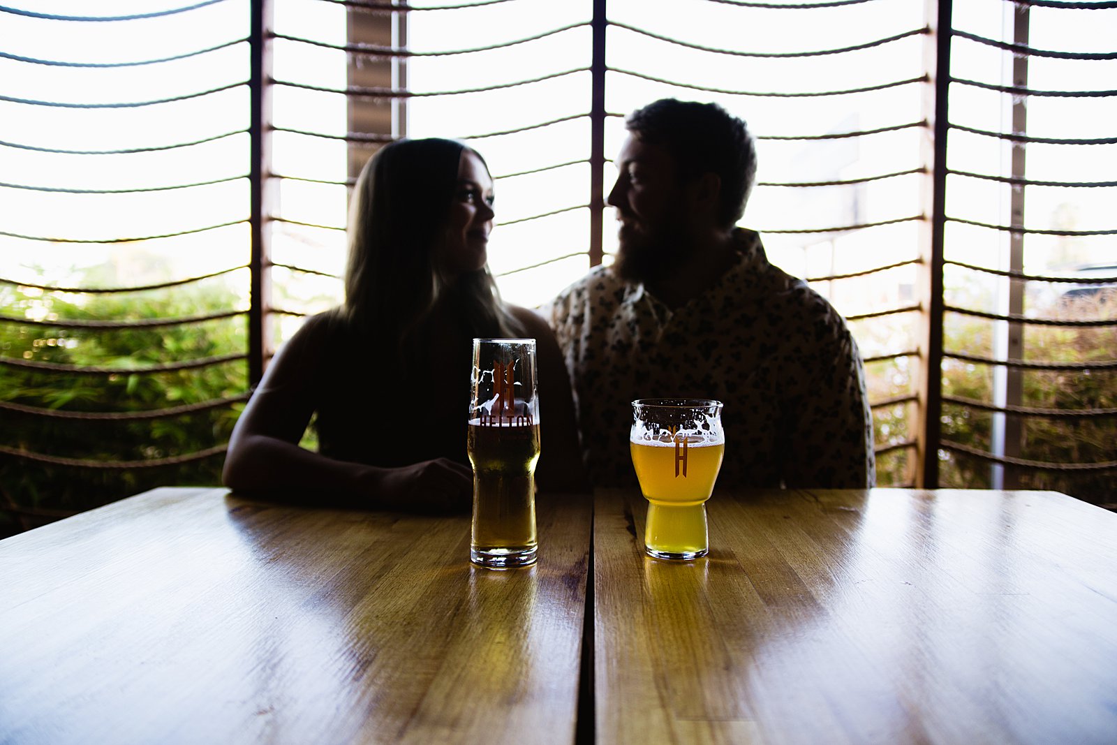 Couple share beers during their Helton Brewery engagement session by Phoenix wedding photographer PMA Photography.