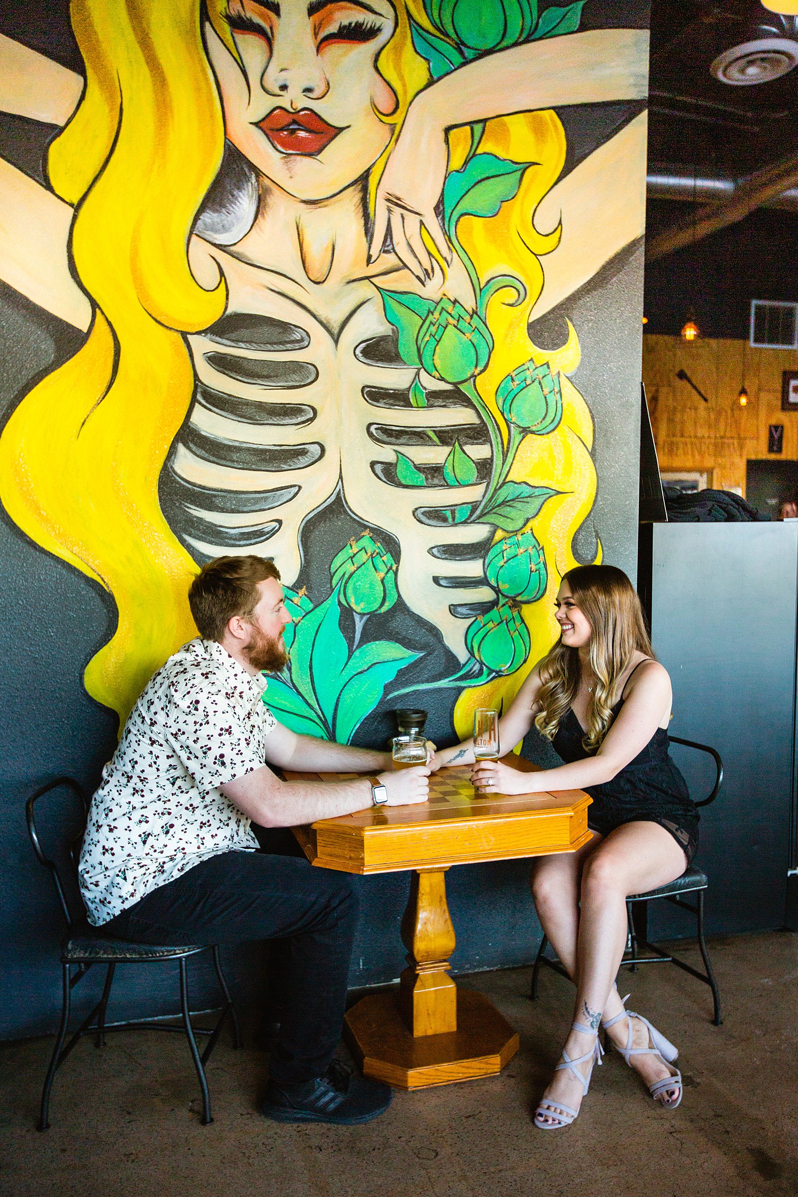 Couple look at each other during their Helton Brewery engagement session by Phoenix wedding photographer PMA Photography.