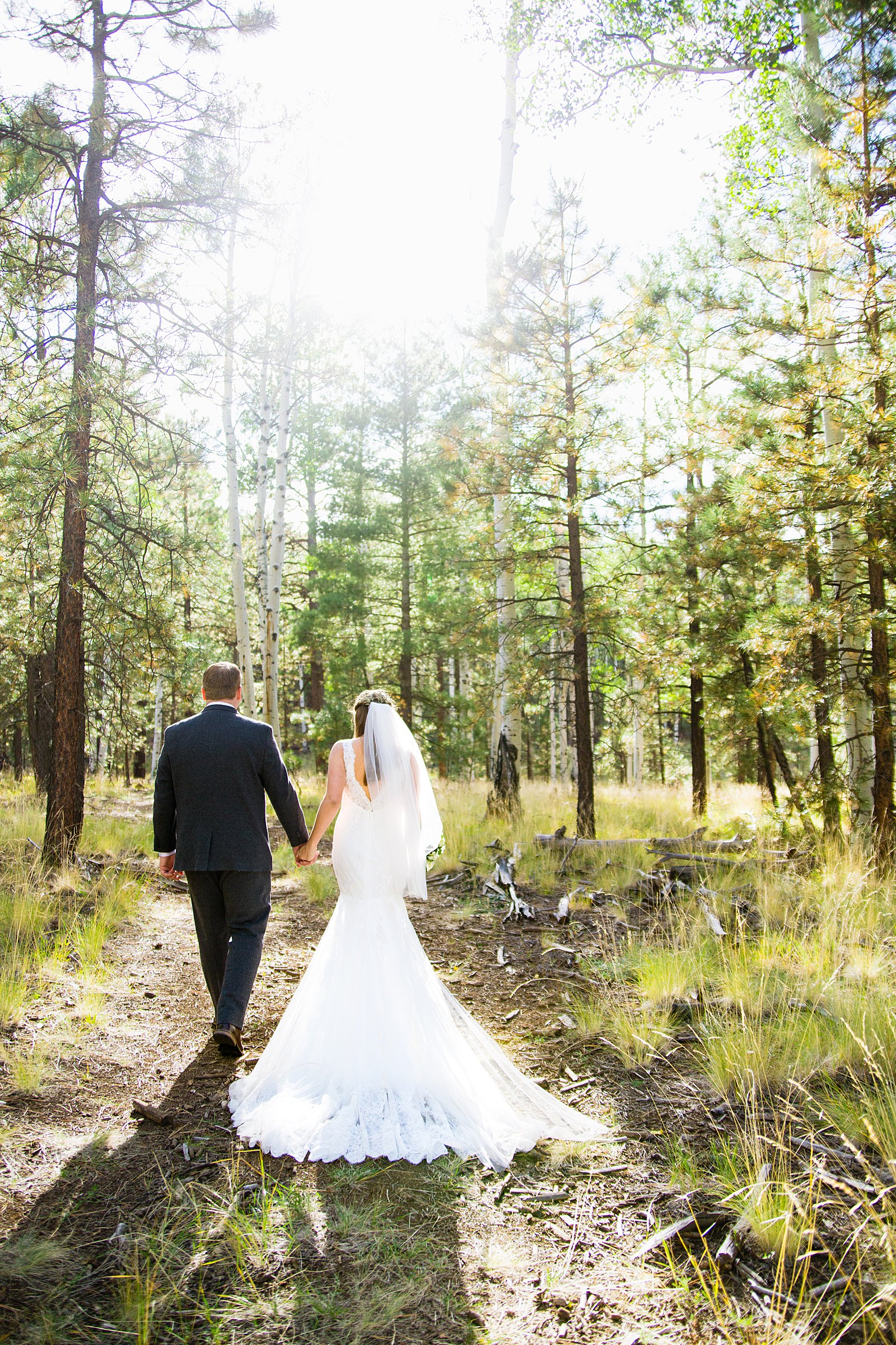 Bride and Groom walking together during their Chapel of the Holy Dove wedding by Flagstaff wedding photographer PMA Photography.