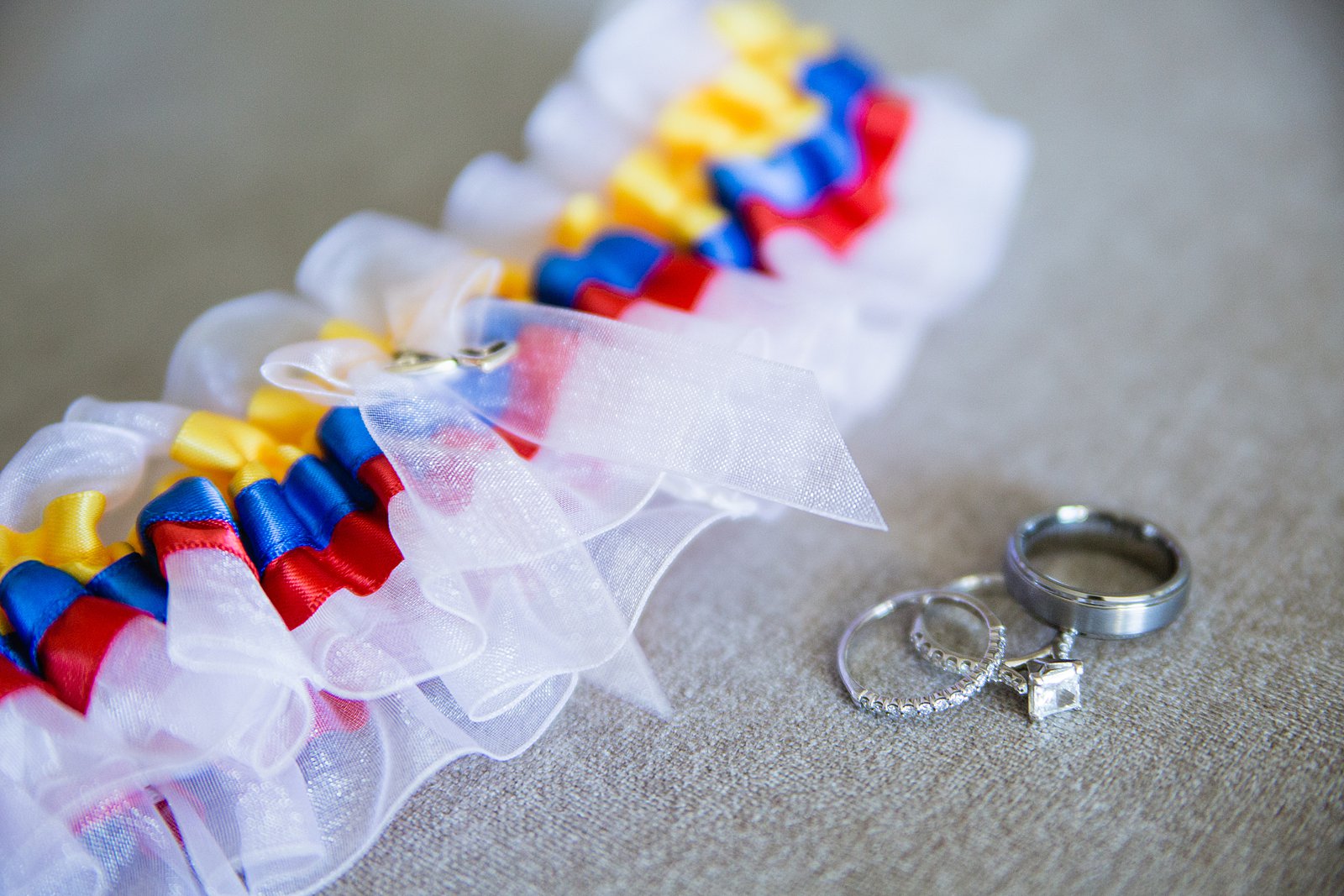 Bride and groom's wedding bands with wedding garter in the colors of the Columbian flag.