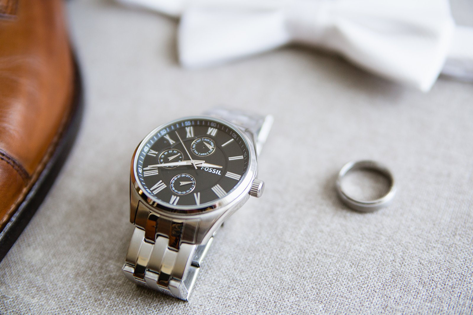 Groom's wedding day details of a fossil watch and wedding band by PMA Photography.
