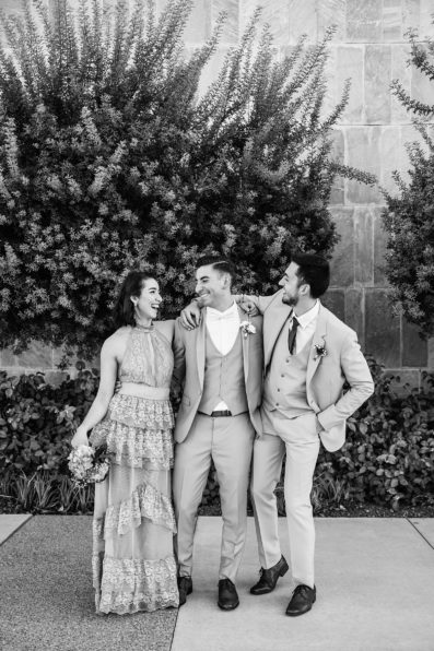 Groom and mixed gender bridal party laughing together at SoHo63 wedding by Chandler wedding photographer PMA Photography.