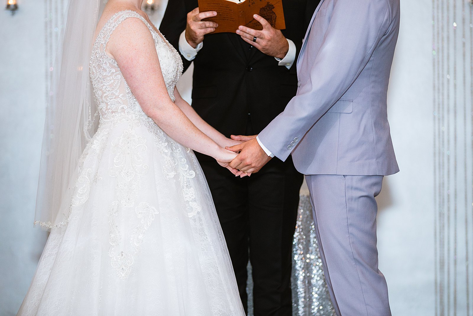 Bride and Groom holding hands during their wedding ceremony at SoHo63 by Phoenix wedding photographer PMA Photography.