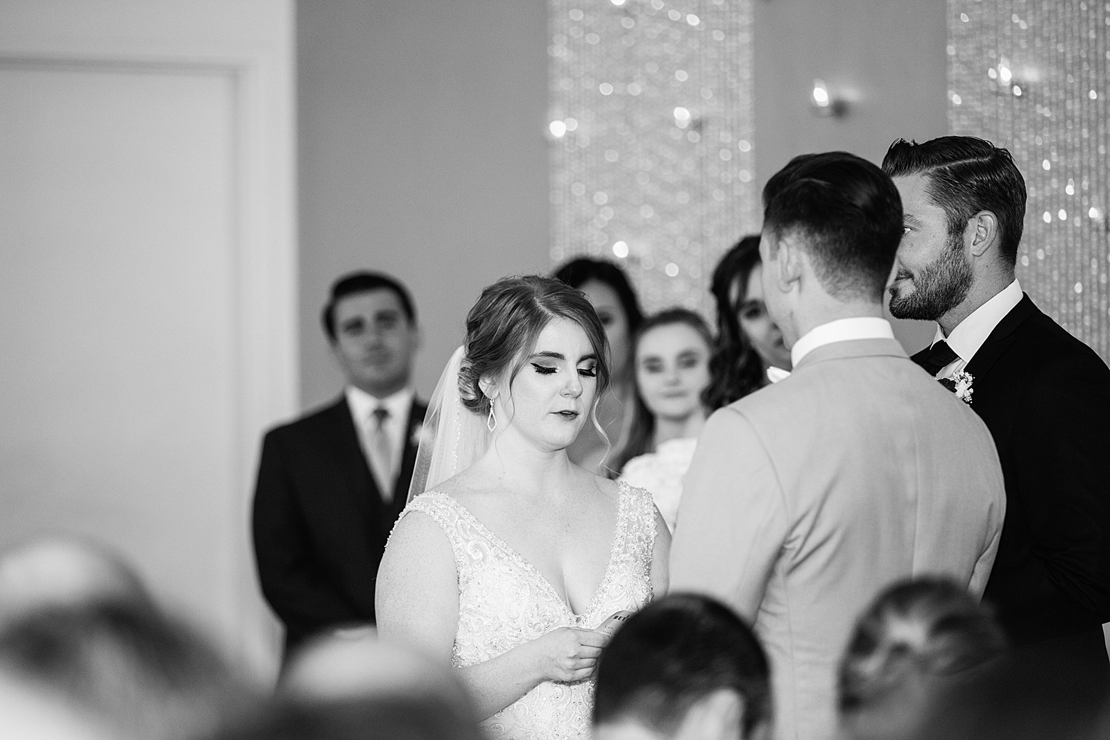 Bride looking at her groom during their wedding ceremony at SoHo63 by Chandler wedding photographer PMA Photography.
