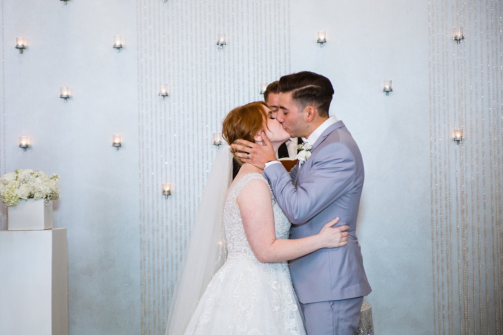 Bride and Groom share their first kiss during their wedding ceremony at SoHo63 by Arizona wedding photographer PMA Photography.