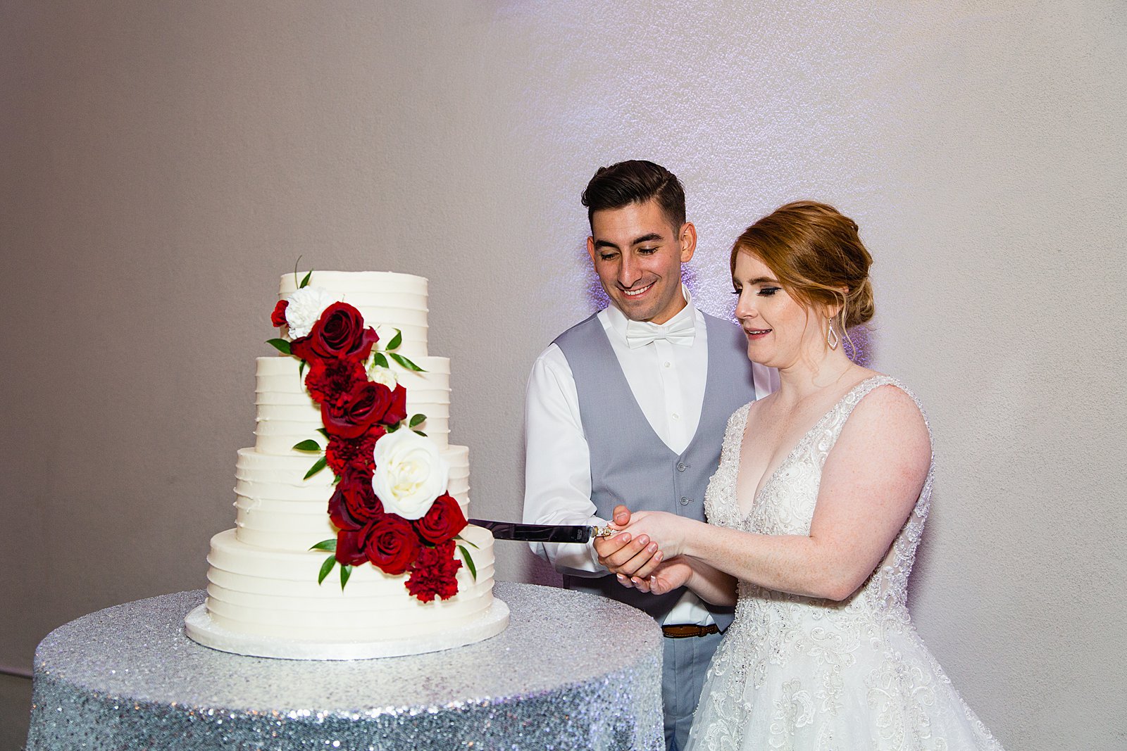 Bride and Groom cutting their wedding cake at their SoHo63 wedding reception by Arizona wedding photographer PMA Photography.