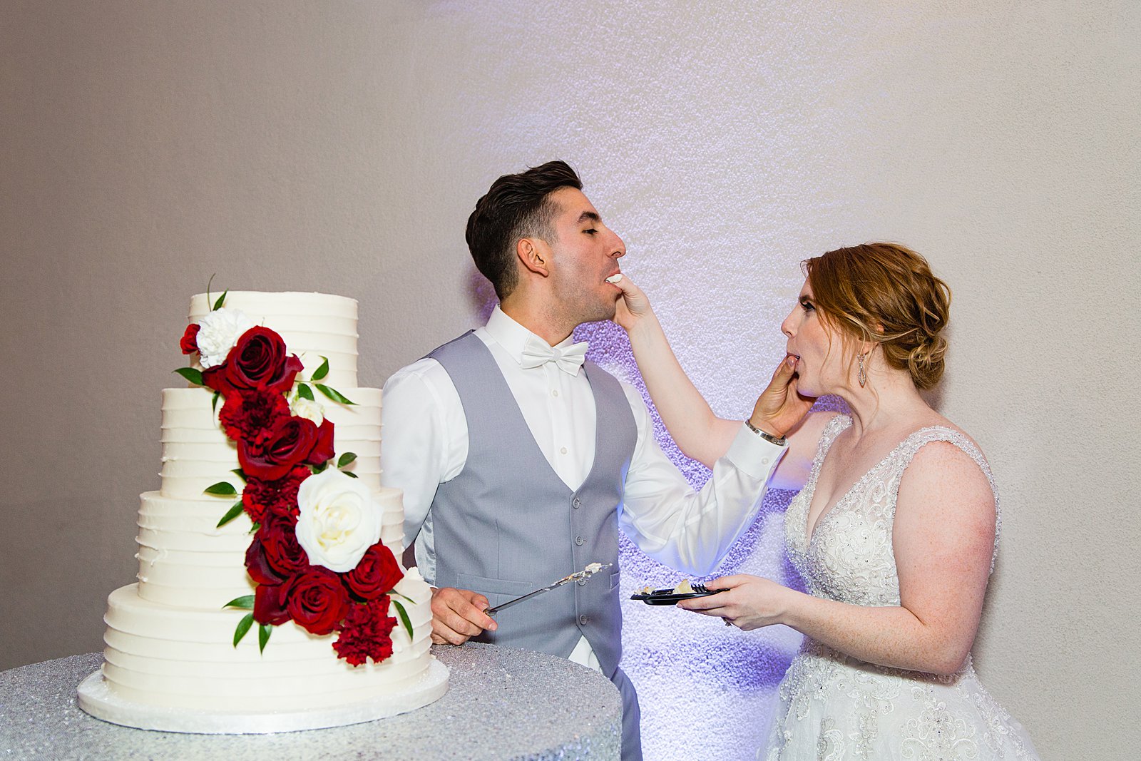 Bride and Groom cutting their wedding cake at their SoHo63 wedding reception by Arizona wedding photographer PMA Photography.