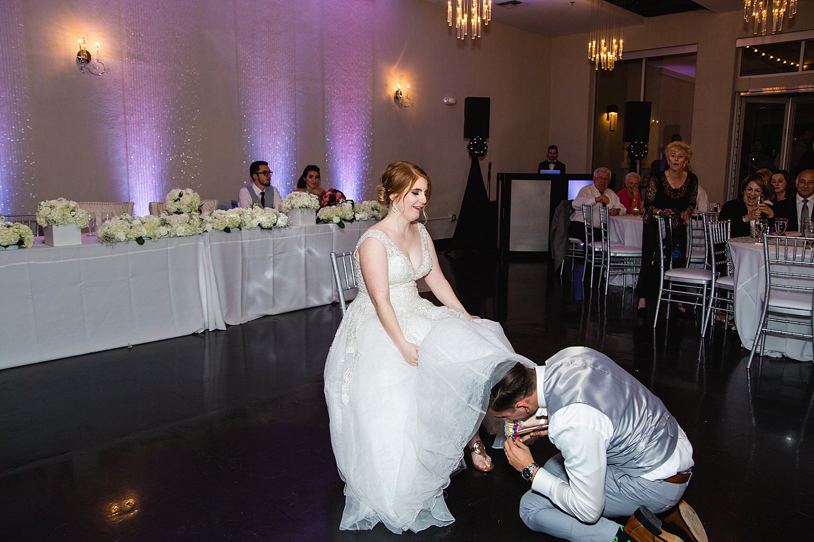 Garter toss at SoHo63 wedding reception by Chandler wedding photographer PMA Photography.