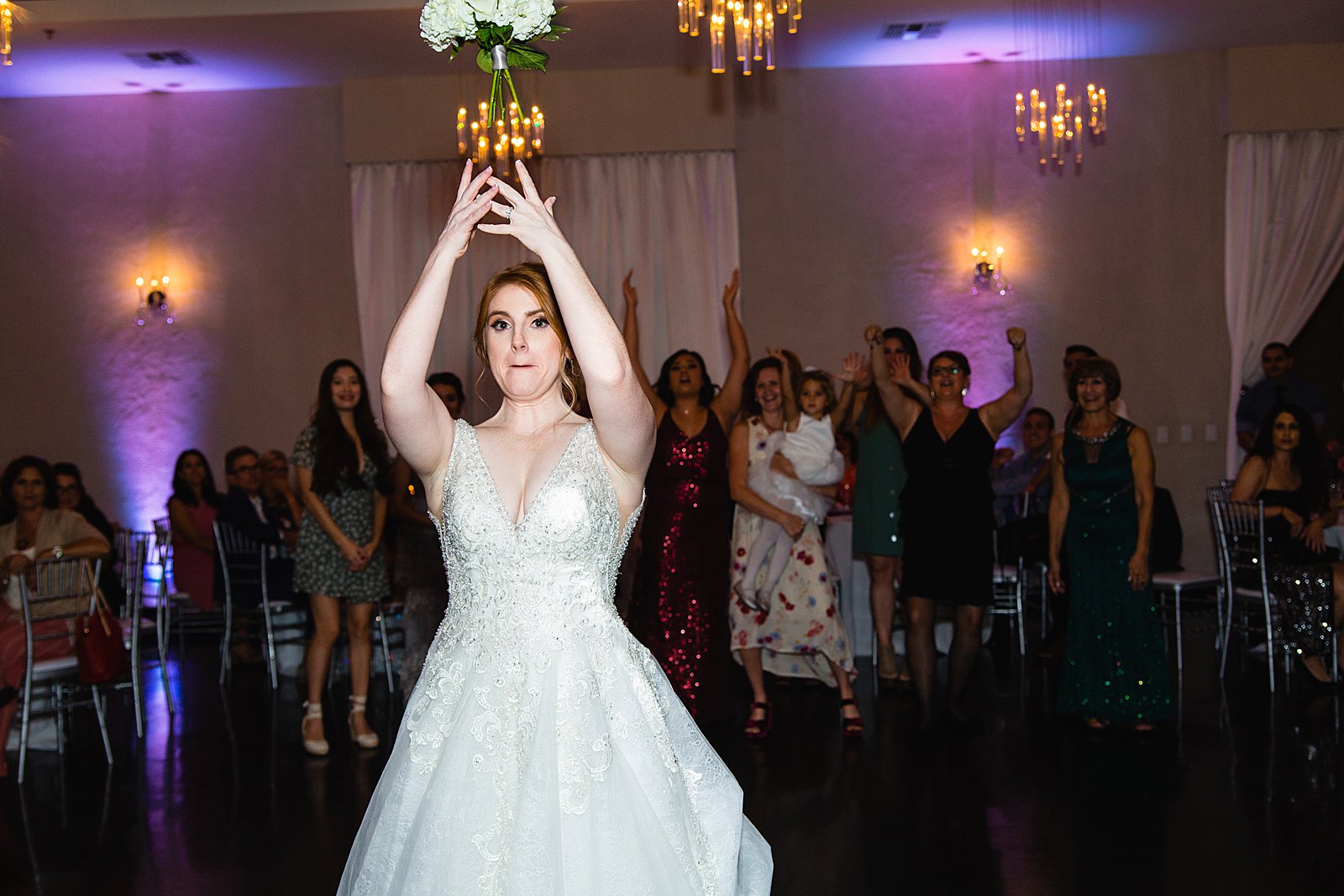 Bouquet toss at SoHo63 wedding reception by Chandler wedding photographer PMA Photography.