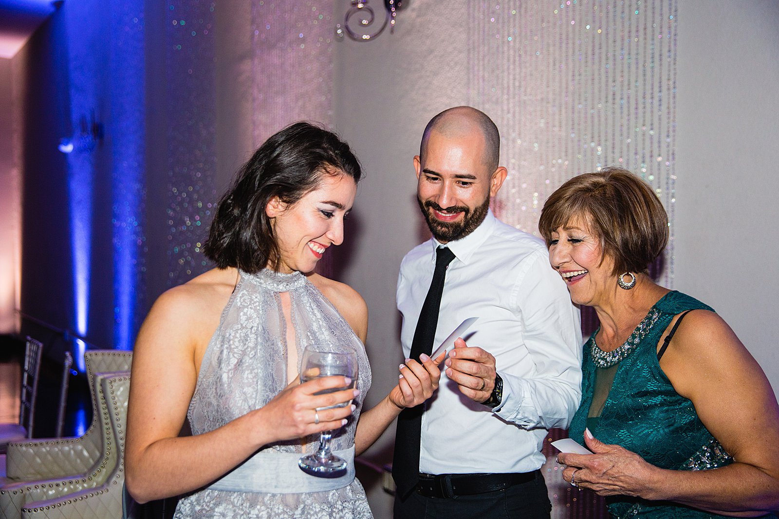 Guests looking at their photobooth images at a SoHo63 wedding reception by PMA Photography.