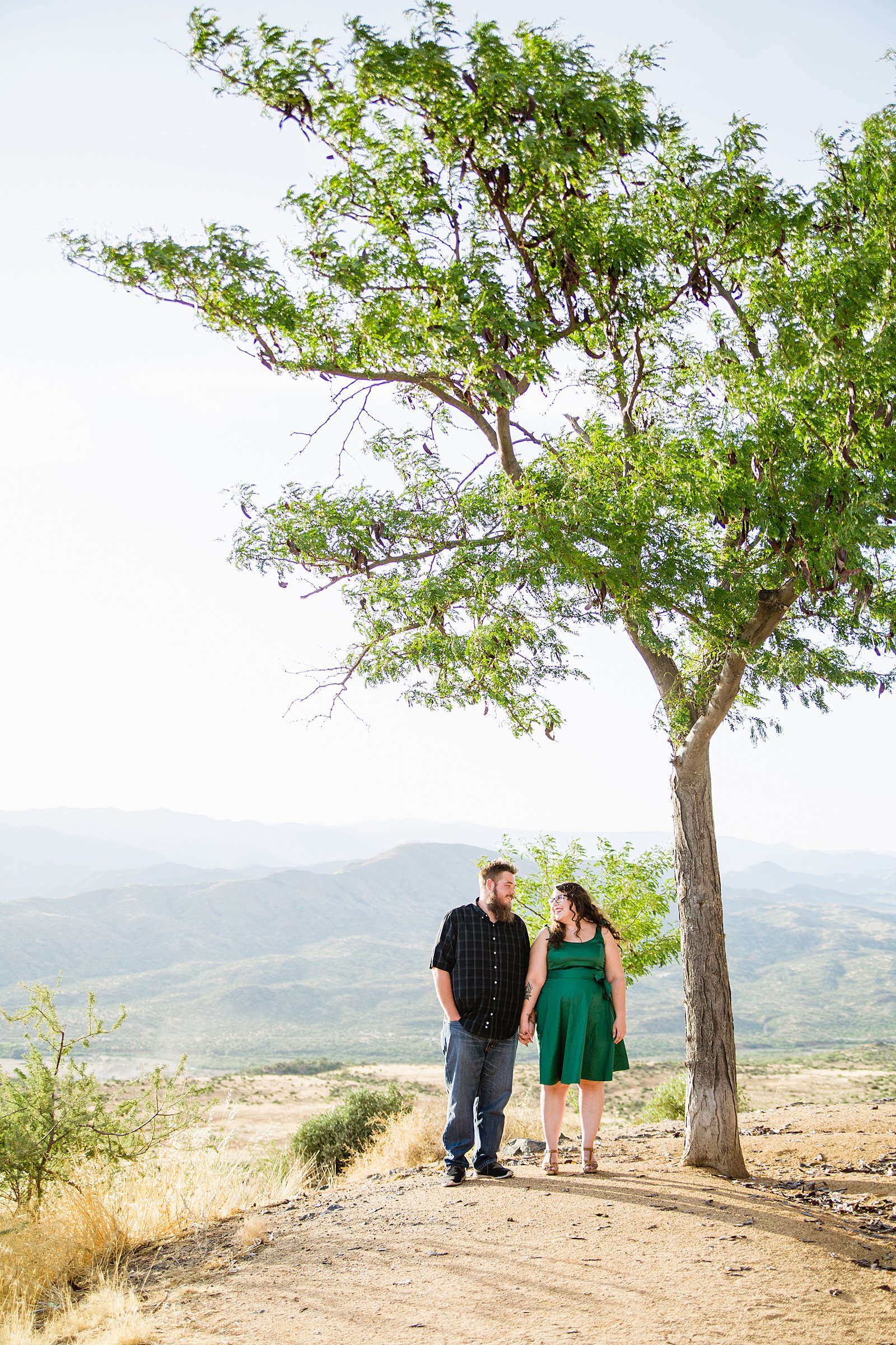 Couple look at each other during their Sunset Point engagement session by Phoenix wedding photographer PMA Photography.