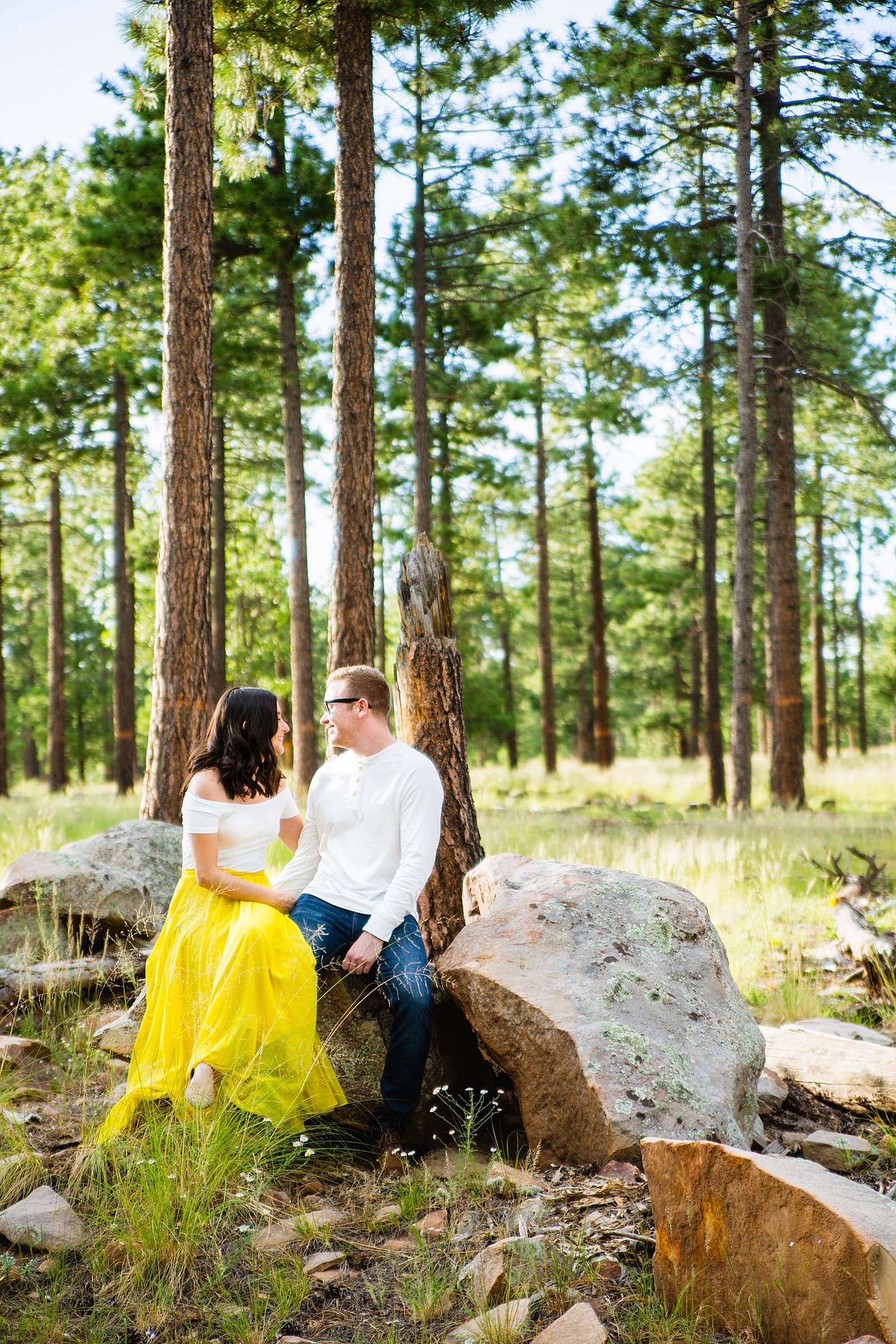 Couple look at each other during their Mogollon Rim engagement session by Payson wedding photographer PMA Photography.